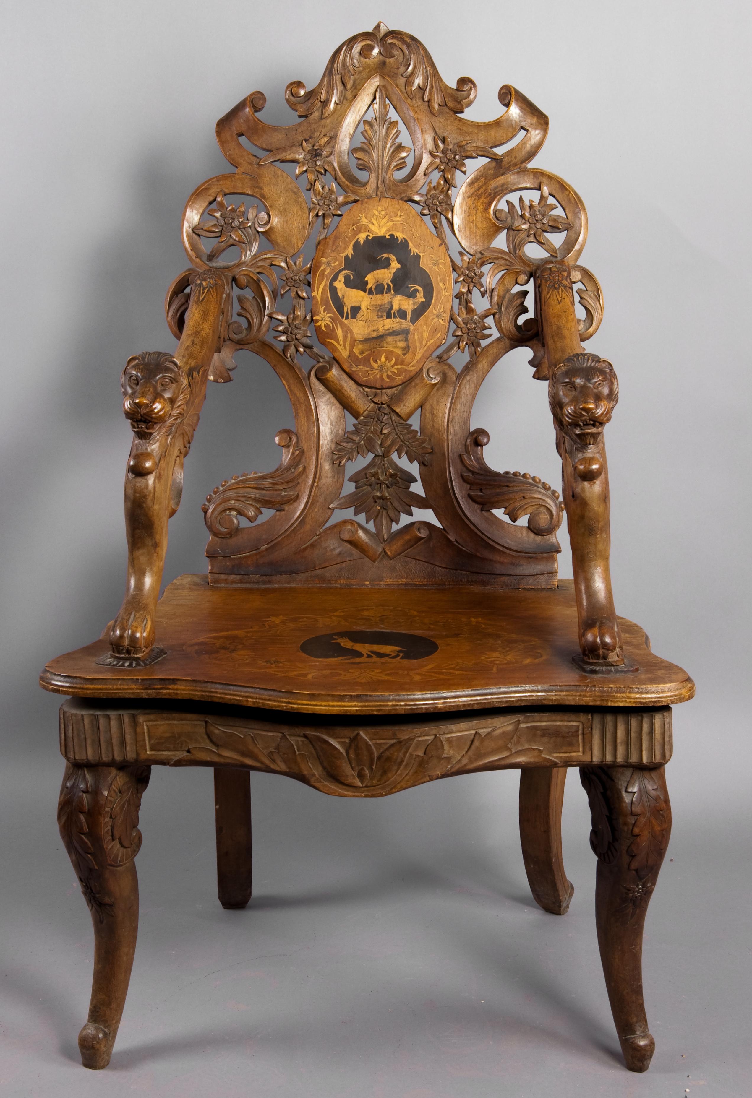 A wonderful carved walnut armchair or throne with finely inlaid seat and back. Superb carved edelweiss and floral ornaments. Lion heads and paws at the base of the arms. Tilt-seat, inside a musical clock. Executed, circa 1900, swiss brienz. (old