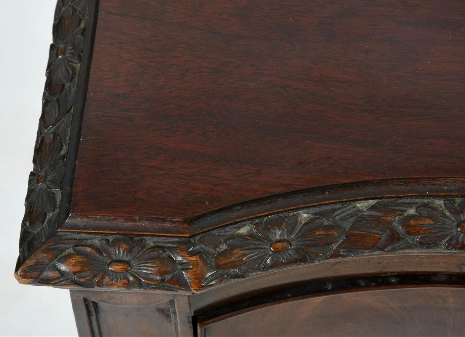A George III style carved mahogany serpentine front serving table, late 19th century, the rectangular serpentine top above a frieze fitted with a single long drawer flanked by two short drawers to either side, raised on acanthus and scroll carved
