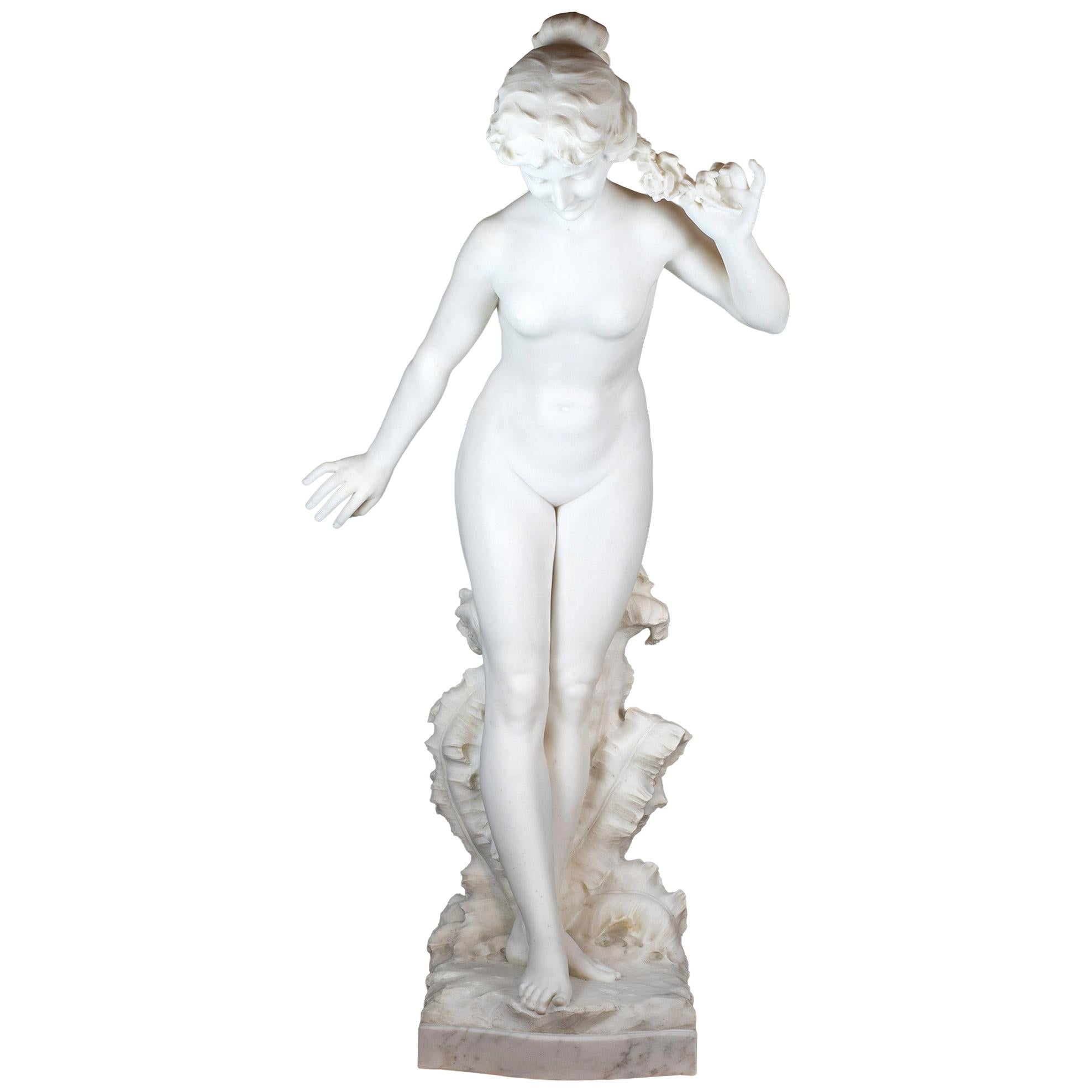 Statue italienne en marbre de Carrare finement sculptée représentant une beauté nue, signée Prof Petrilli/Galleria Bazzanti/Firenze. Vient en paire avec le piédestal en marbre dans la dernière photo. 

Titre : Flora (Allégorie du