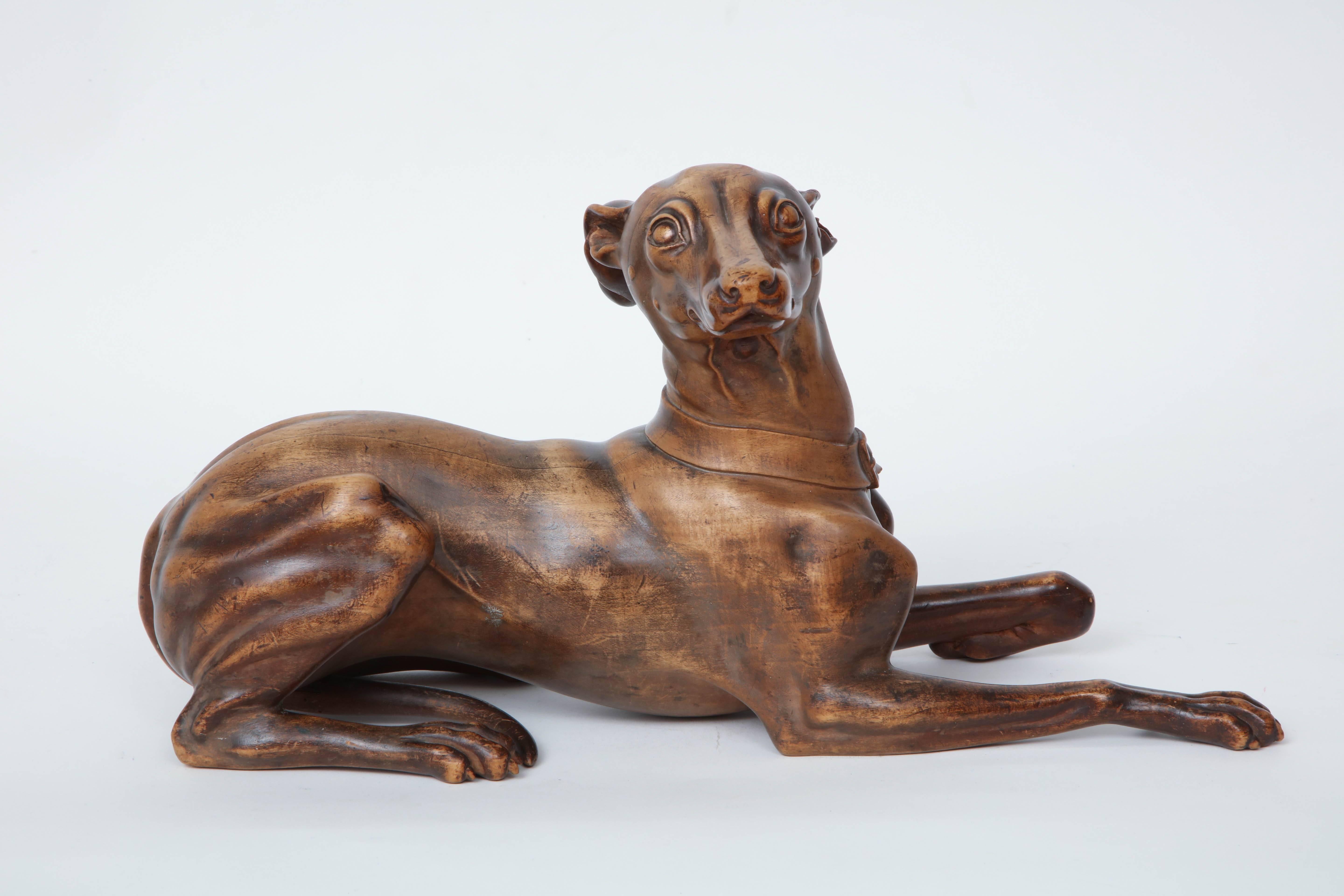 A finely carved fruitwood or beechwood recumbent whippet, probably English, circa 1900s. Carved in an extremely realistic manner with a very fluid hand. Good color and patina with a wax finish.

 