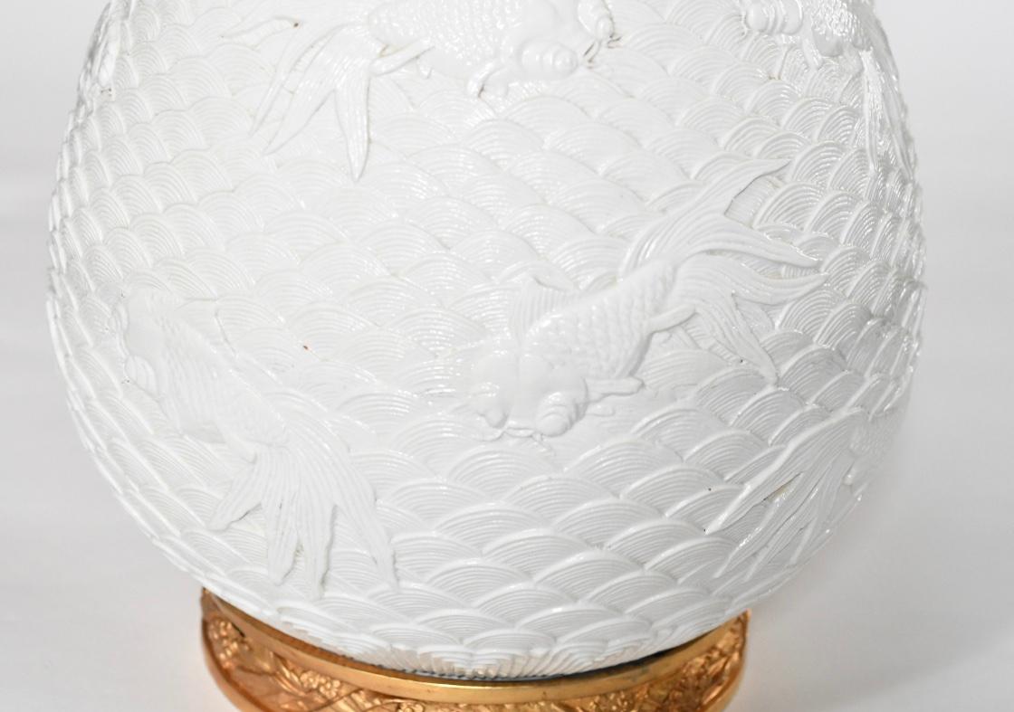 Paar fein geschnitzte weiße Porzellanlampen mit Fischdekor. Sockel und Dekoration aus vergoldetem Messing.
Maße: Bis zur Oberkante des Porzellans 18,5