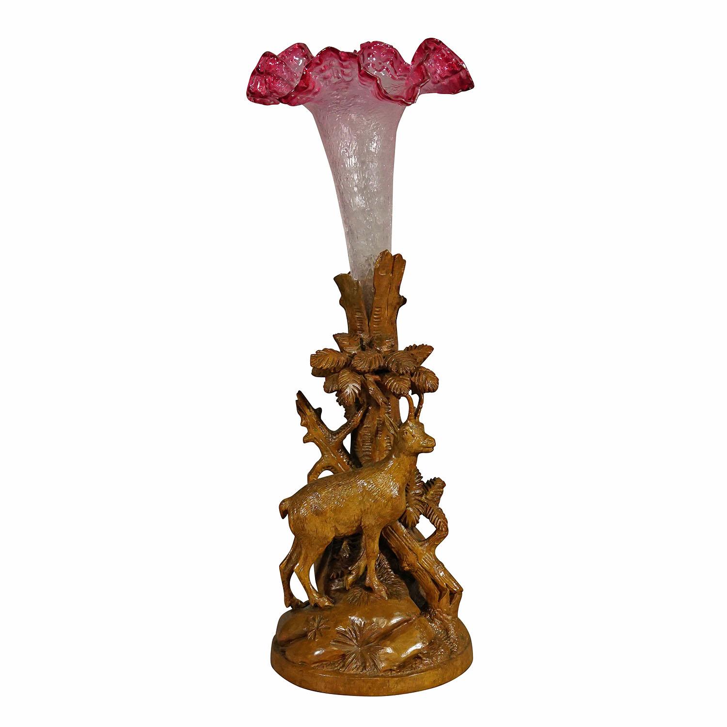 Chamois en bois finement sculpté avec vase en verre, Brienz, vers 1900.

Sculpture en bois délicatement sculptée à la main représentant un chamois debout sur une base rocheuse avec trois souches et un vase en verre antique. Une sculpture très