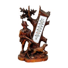 Présentoir thermomètre en bois finement sculpté, chasseur et lévrier, 1910
