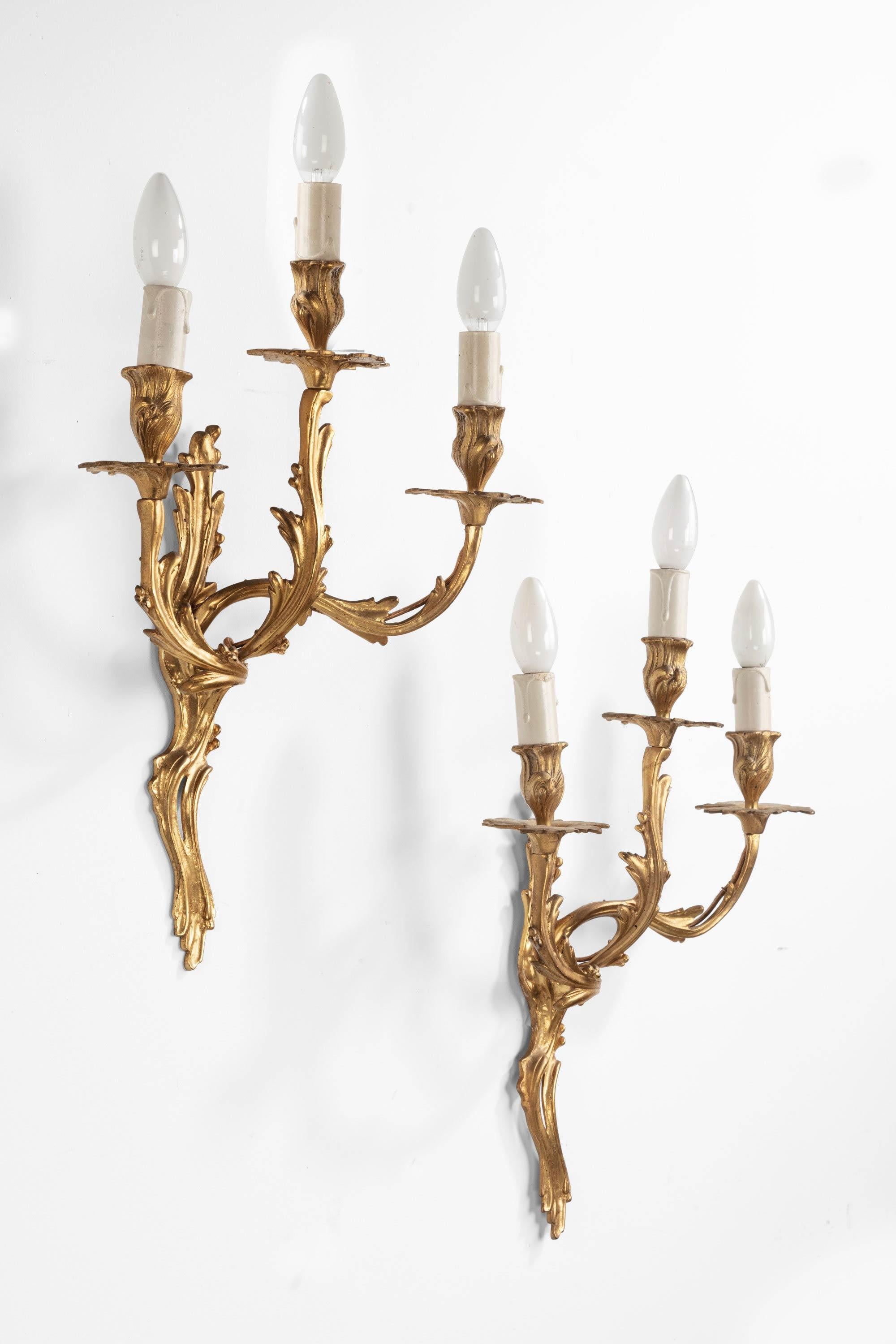 A pair of finely cast, Rococo wall lights with three arms. Sinuously carved in leaf and foliage.
 