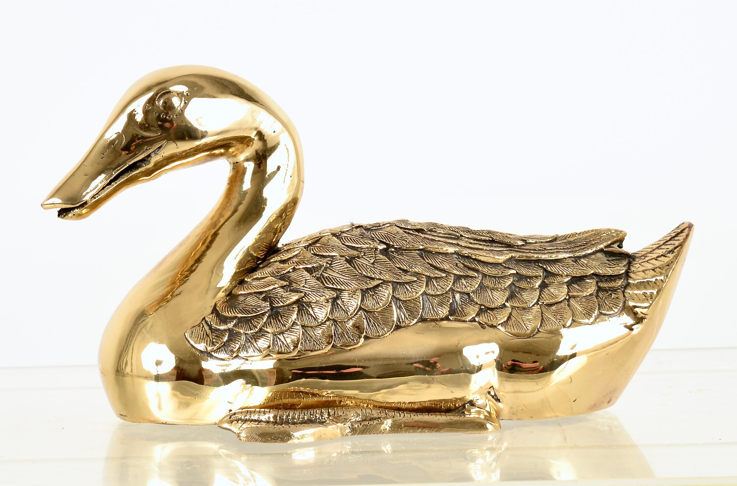 Beautifully made duck sculpture. Note the fine detail of the feathers and the foot. This piece is solid brass, quite heavy and a nice size at almost a foot long. Exceptional quality and fine attention to detail. It is newly polished and lacquered.