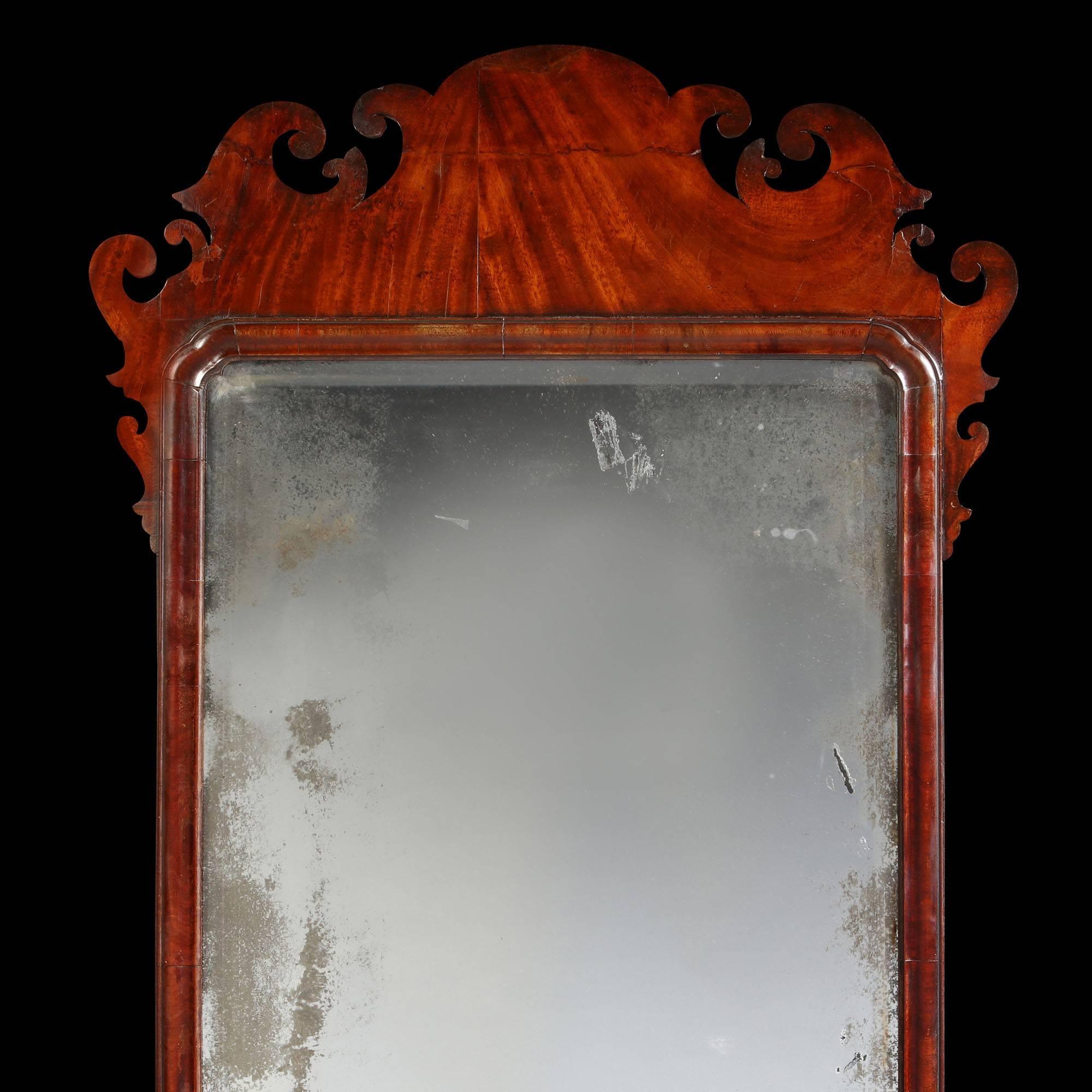 A finely figured Georgian mahogany mirror, with scrolling detail to the frame and original bevelled mercury mirror plate.