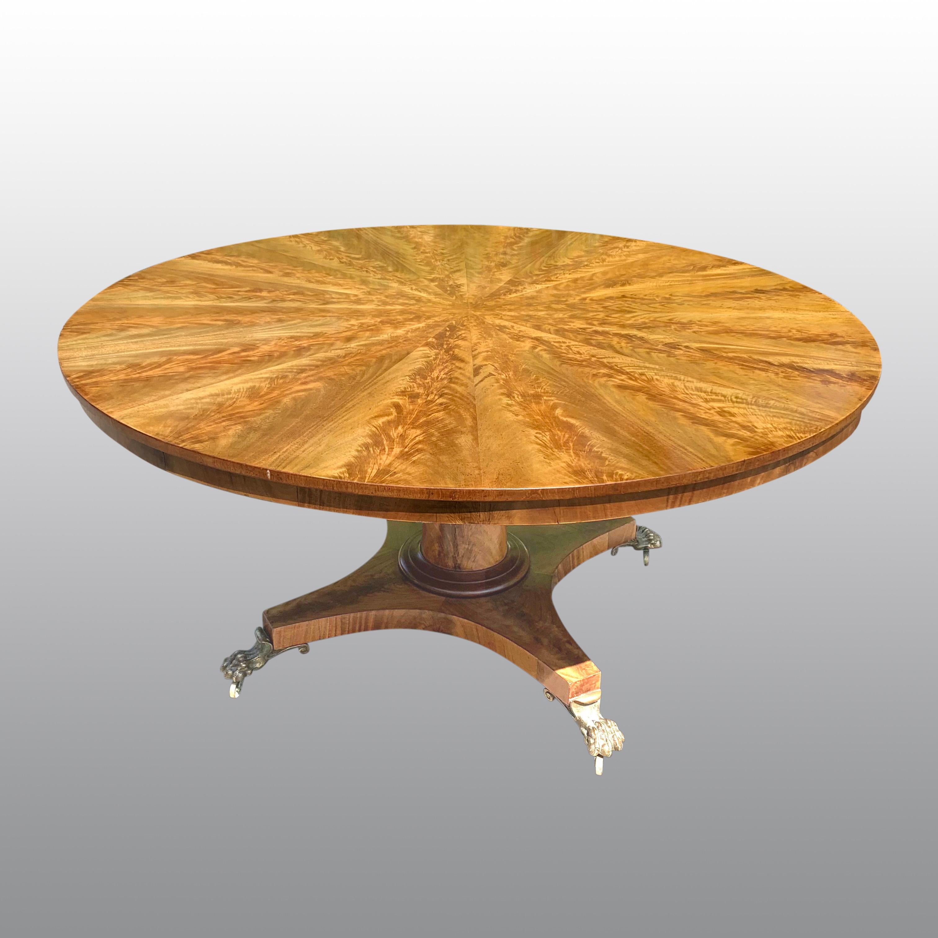 A highly impressive and excellent quality large circular center table with superb multi-segmentmented top incorporating richly figured and matched radial segments supported on a plain slender apron and raised on a 'gun-barell' column with four-splay