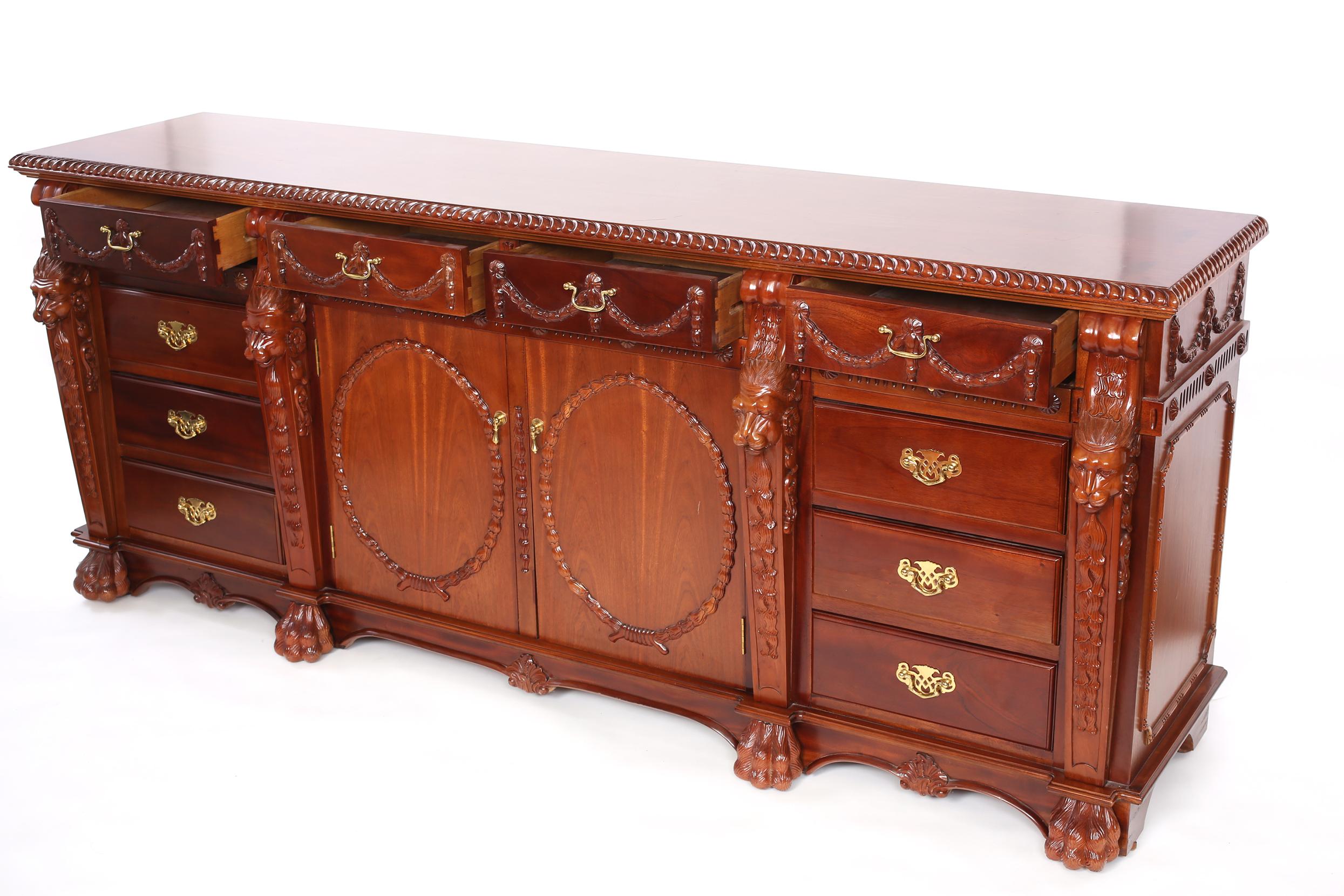 Credenza/server in legno di mogano intagliato a mano all'inizio del XX secolo con intagli a testa di leone, piedi ad artiglio e dettagli di design esterni. La credenza/server è in buone condizioni e presenta un'usura dovuta all'età o all'uso. Lo