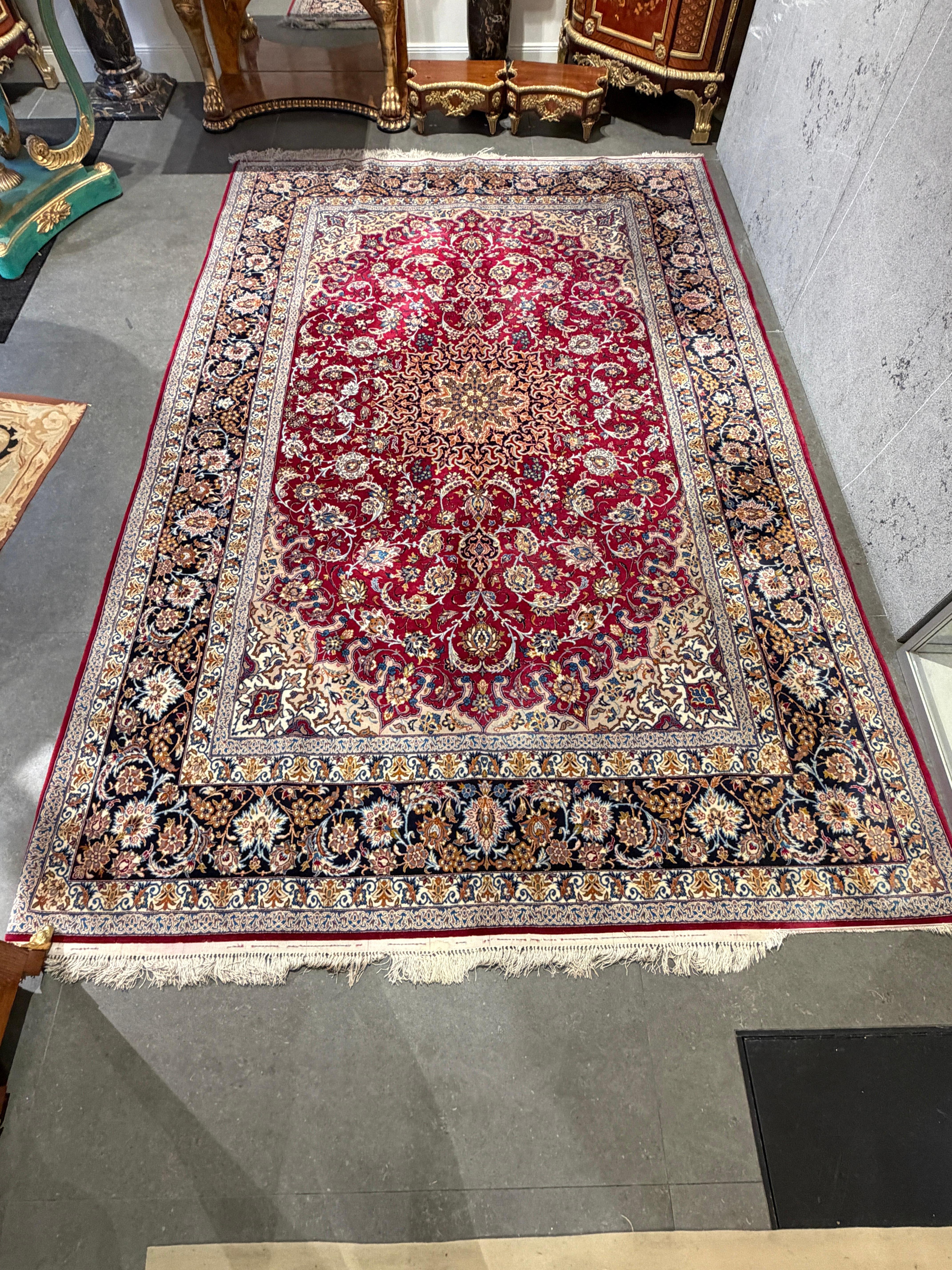 This elegant Isfahan carpet, woven with exceptional fineness and artistic precision, is a distinguished example of one of Persia’s most celebrated weaving traditions. Set against a radiant deep-red field, the central medallion unfolds in a