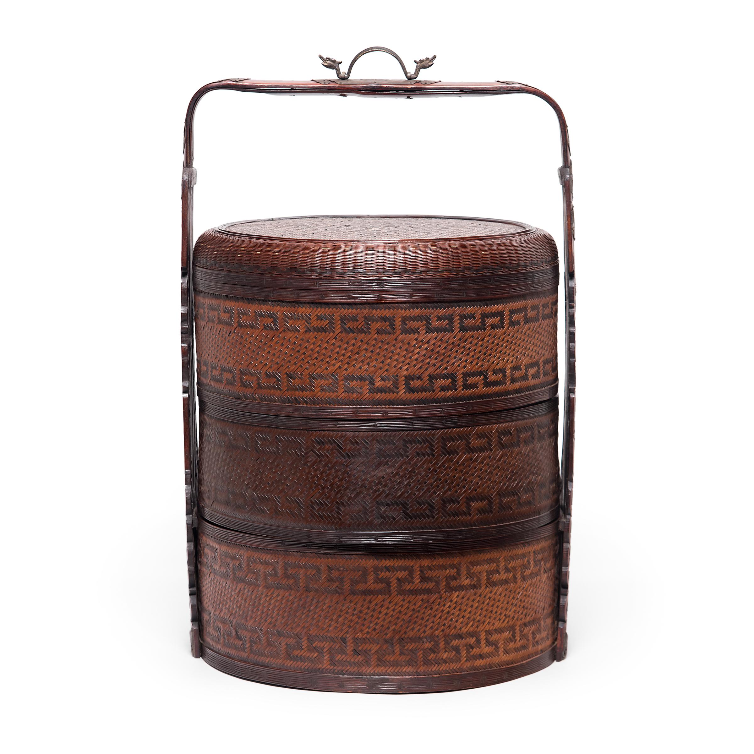 The basic form of this three-tiered Chinese box has remained unchanged for a thousand years. Used like a modern lunchbox, each tier of this portable stacking box would have been filled with food and carried around by the handle. With an elaborate