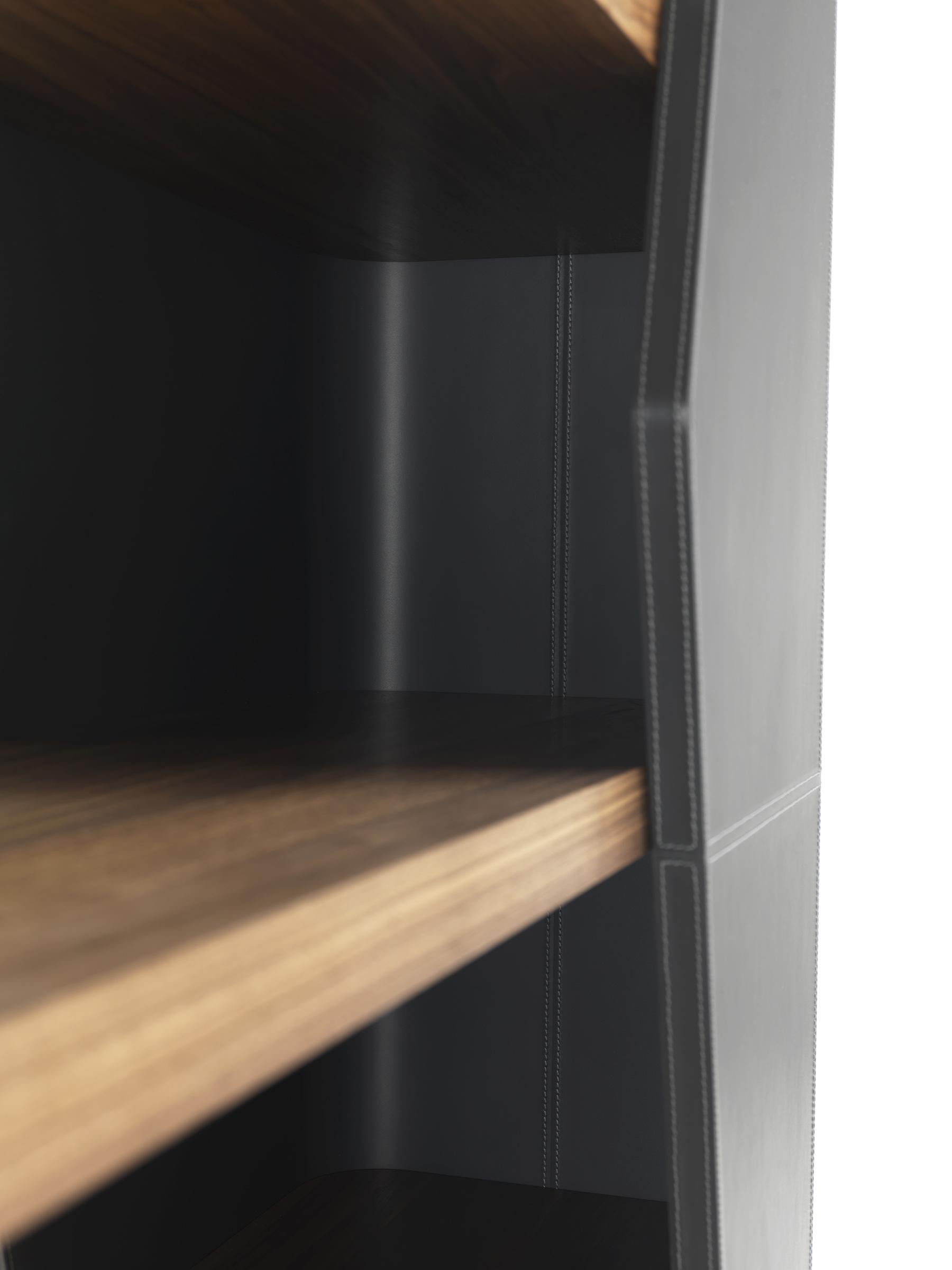 Shelf characterized by asymmetrical supports in curved and shaped multilayer wood panels, that can either be veneered or covered with leather, in which are fitted six 5 cm thick shelves in veneered multilayer.

Made in Italy and designed by Karim