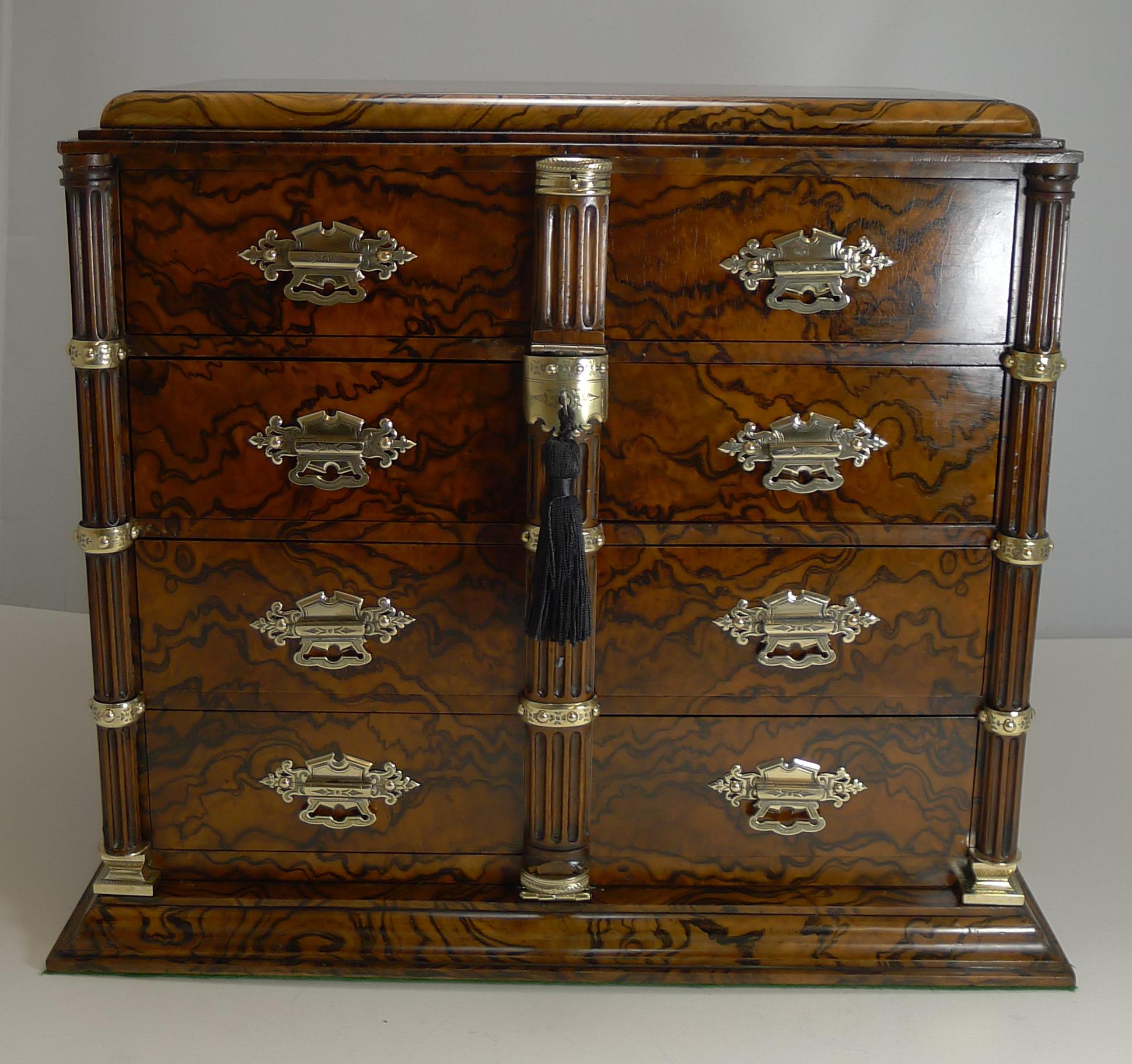 About as fine as they get, this large Burr walnut cigar cabinet is a magnificent quality box beautifully made.

Each corner has a carved column with a polished brass base and brass mounts around the columns, all beautifully hand engraved. All of
