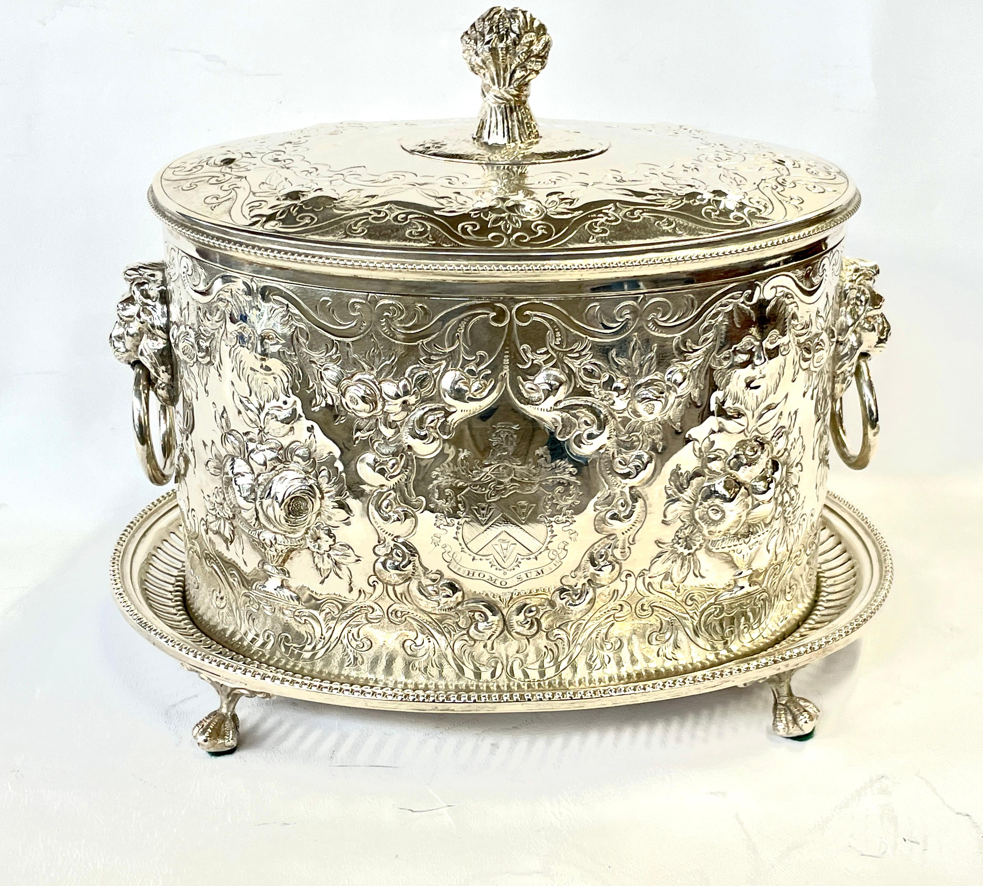 Quite possibly the finest antique English Sheffield silver plate oval biscuit box with extraordinary deeply hand chased and engraved motifs overall plus a fabulous armorial crest in the center of the cartouche. 
Please also note the superbly hand