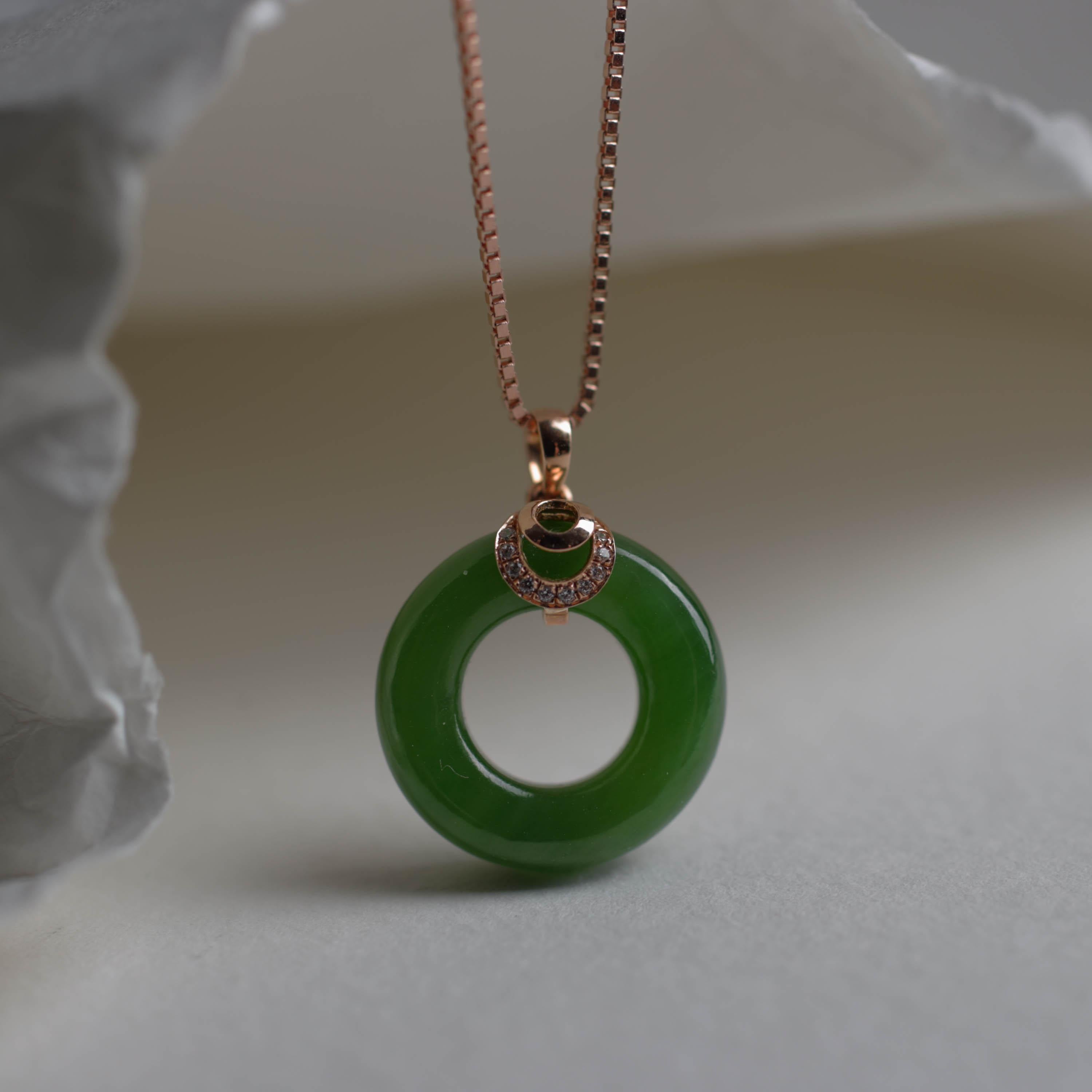 This ring-shaped hand-carved pendant features the finest green nephrite jade there is. This Chinese nephrite comes from the North-Western mountains of China and the nephrite features uncommonly pure apple-green coloring, together with extraordinary