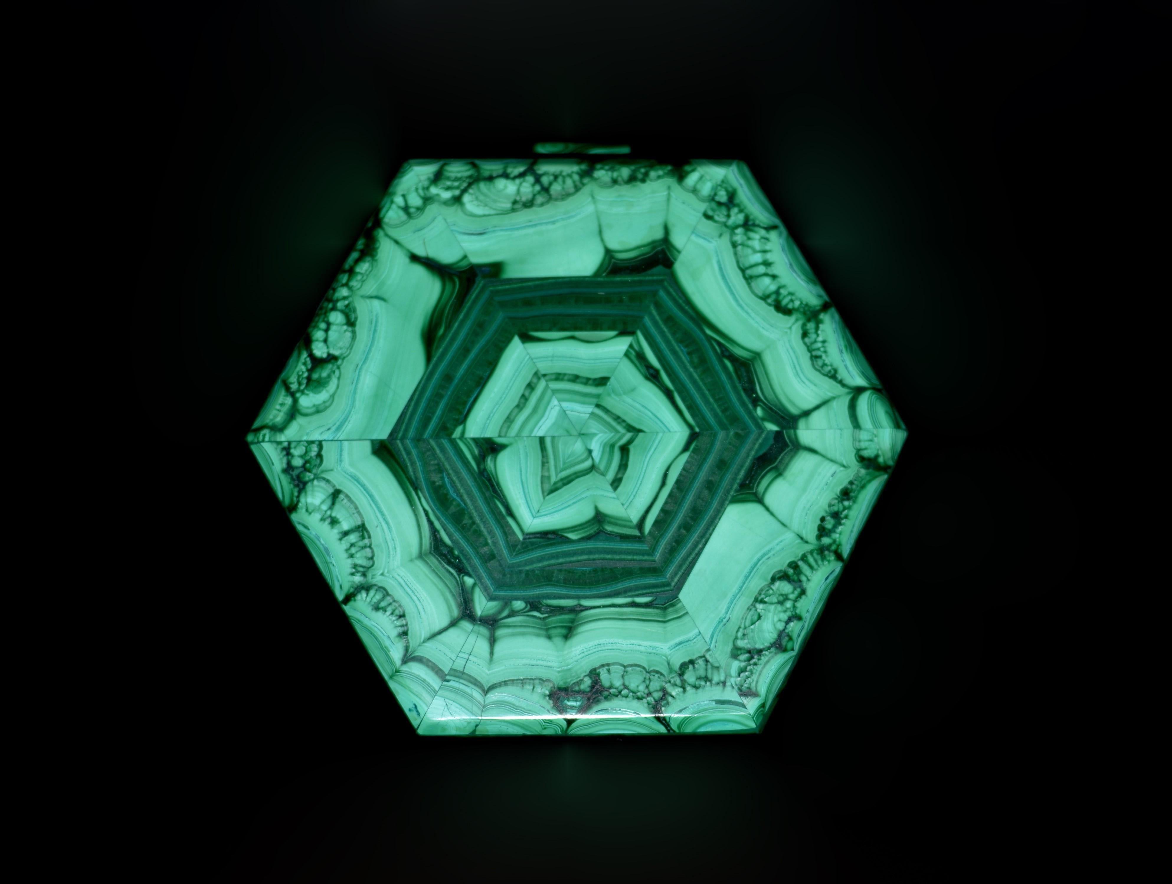 No es una caja de malaquita cualquiera. Es una obra maestra única de arte y maravilla natural. Esta impresionante pieza hexagonal está elaborada con malaquita de la mejor calidad, meticulosamente seleccionada y dispuesta para crear un cautivador