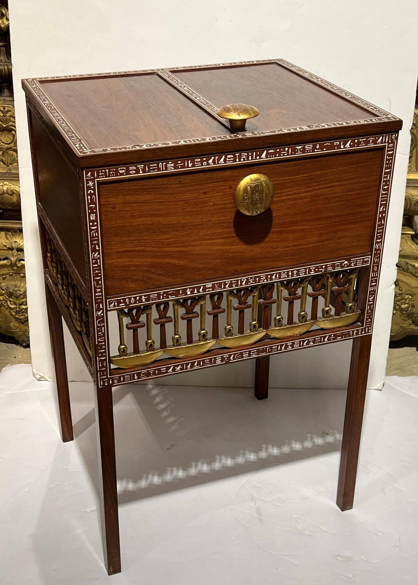 A 1930s reproduction of King Tutankhamun's chest with hieroglyphics. Wood construction with inlaid hieroglyphics and Glided detail. Features a hinged top with original Gilded knobs and divided interior with pierced skirt on tall squared legs.
