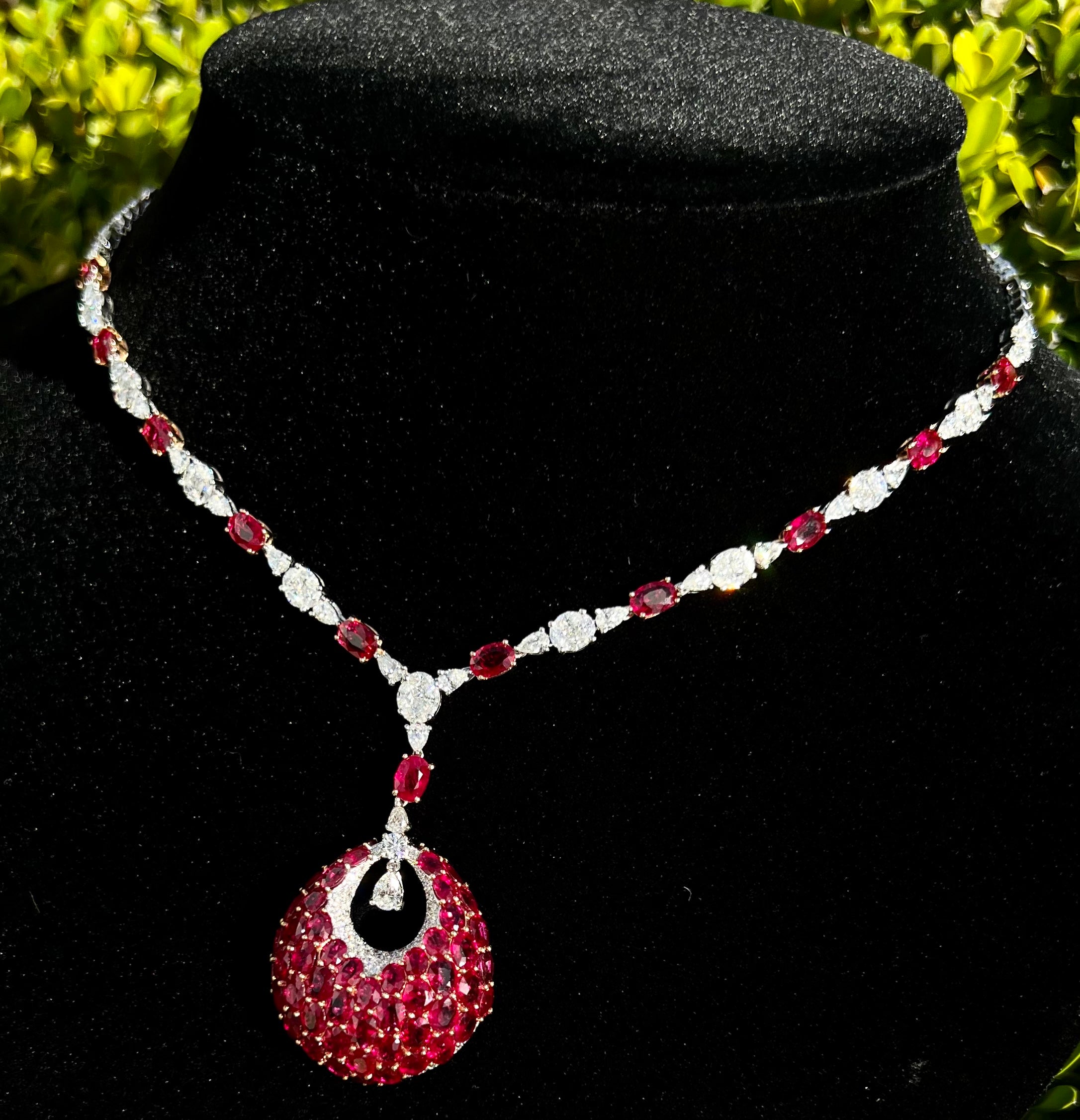 Very opulent, ladies estate 18 karat white gold, 30 carat Burmese ruby and diamond necklace features the finest quality Burmese rubies and D color white sparkling diamonds. In the center of the necklace, an elegant open circular pear drop dangles
