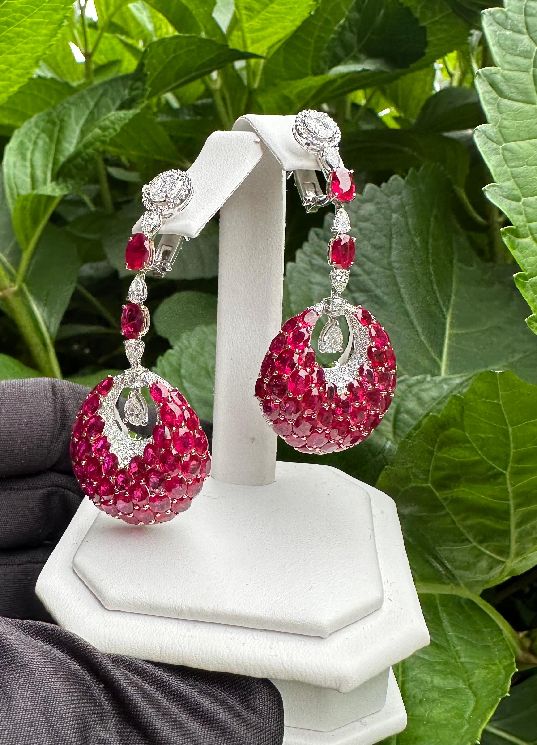 Very opulent, ladies estate 18 karat white gold, 35.21 carat Burmese ruby and diamond earrings feature the finest quality Burmese rubies and D color white sparkling diamonds. On the bottom of each earring, an elegant open circular pear shaped drop