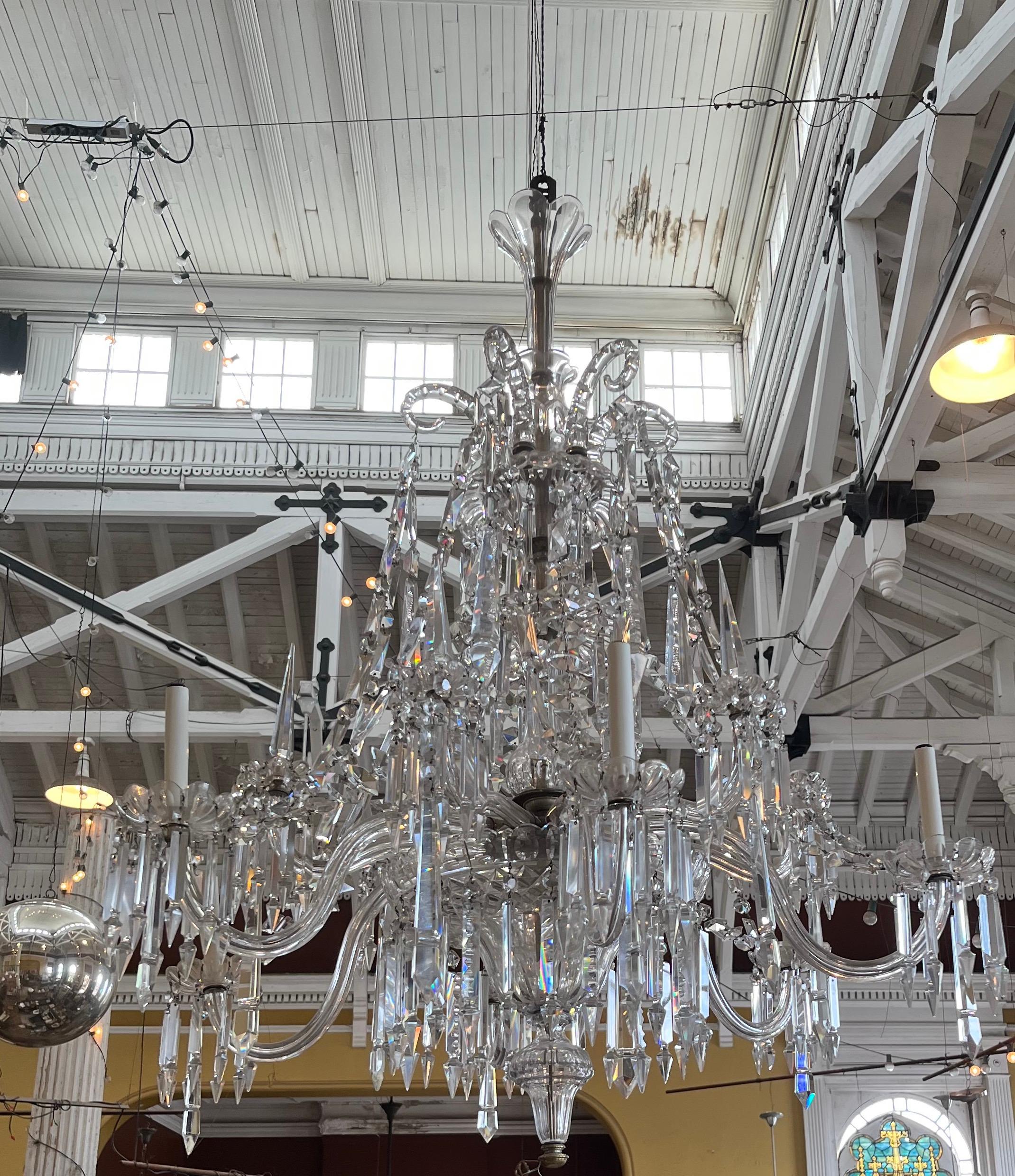Lampadario a dodici bracci e sei luci in cristallo tagliato di F. & C. Osler, 1850 circa.  
L'albero a forma di balaustro e tulipano in più parti è collegato a un'armatura con motivo Osler unico nel suo genere, con bastoni da pastore, drappi a