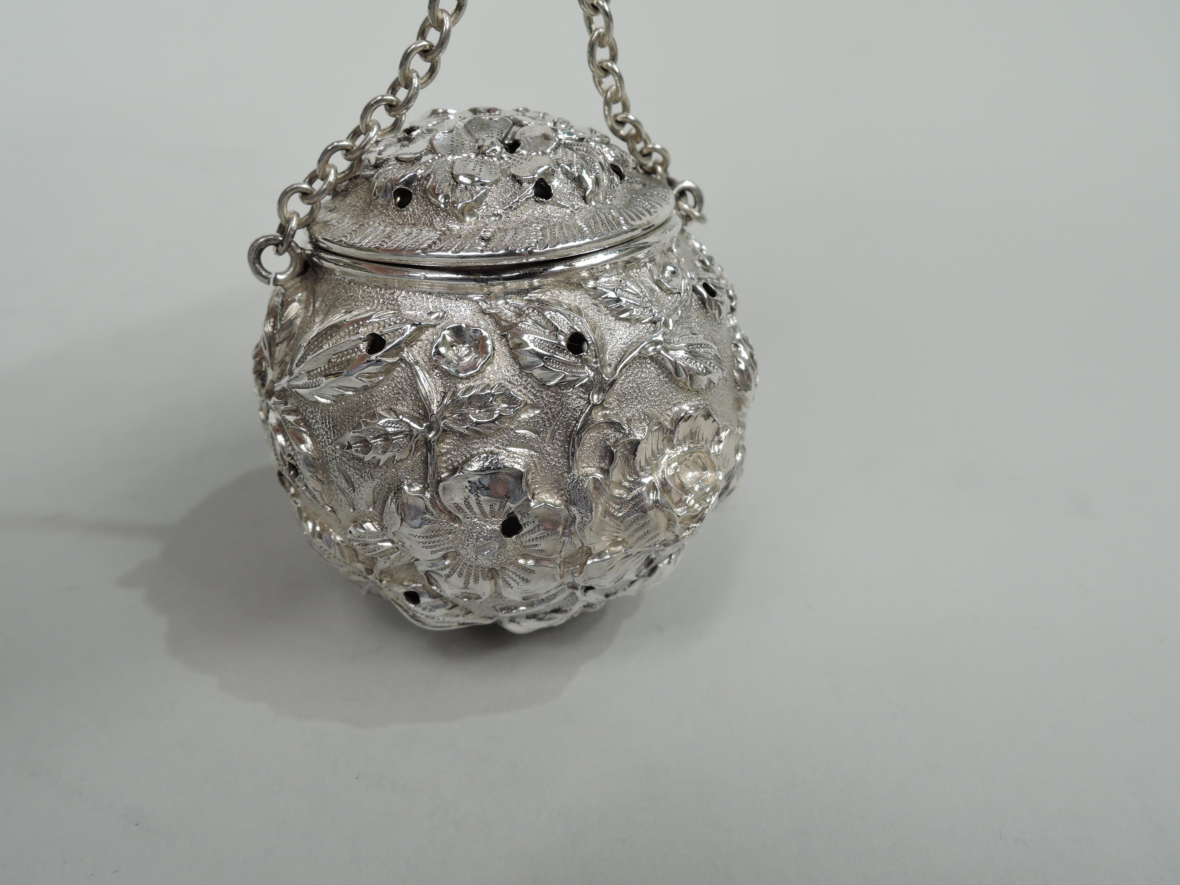Finest quality sterling silver tea ball. Made by Stieff in Baltimore, circa 1920. Floral repousse on stippled ground. Allover piercing for even diffusion and snuggly-fitted hinged cover guaranteed not to spill open in the pot. Chain with ring finial