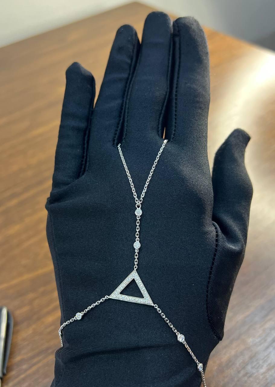 Ce bracelet exquis présente une délicate chaîne en or blanc ornée de diamants ronds étincelants. La pièce maîtresse est un triangle géométrique incrusté de diamants scintillants, ajoutant une touche d'élégance moderne. La chaîne réglable assure un