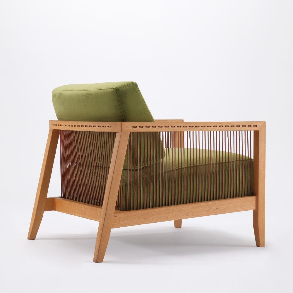 Le fauteuil Finn est entièrement fabriqué à la main. Son aspect unique provient de cordes en cuir véritable qui s'enroulent autour d'un cadre robuste en chêne massif. Avec son tissu velours doux et son assise ergonomique, il vous accompagnera dans