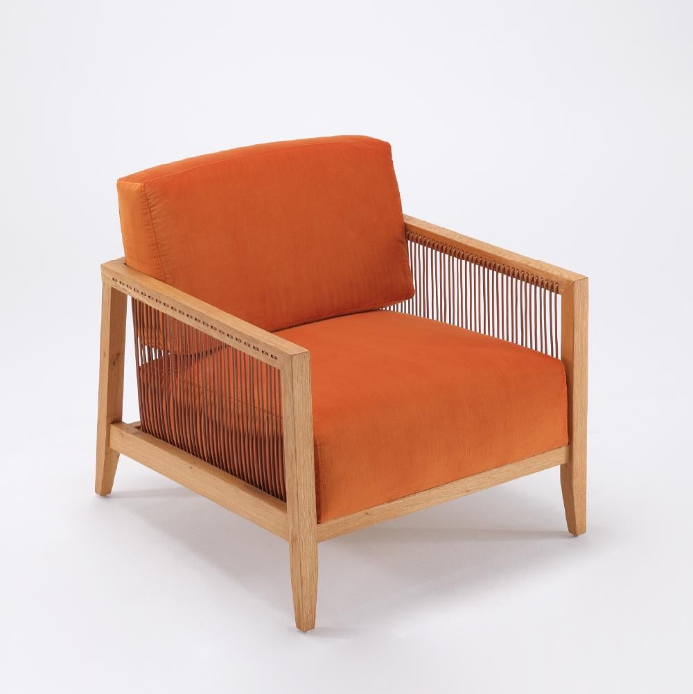 The Finn Armchair is crafted entirely by hand. Its unique appearance comes from genuine leather cords that wrap around a sturdy solid oak frame. With its soft velvet fabric and ergonomic seating, it will accompany you in your most enjoyable moments.