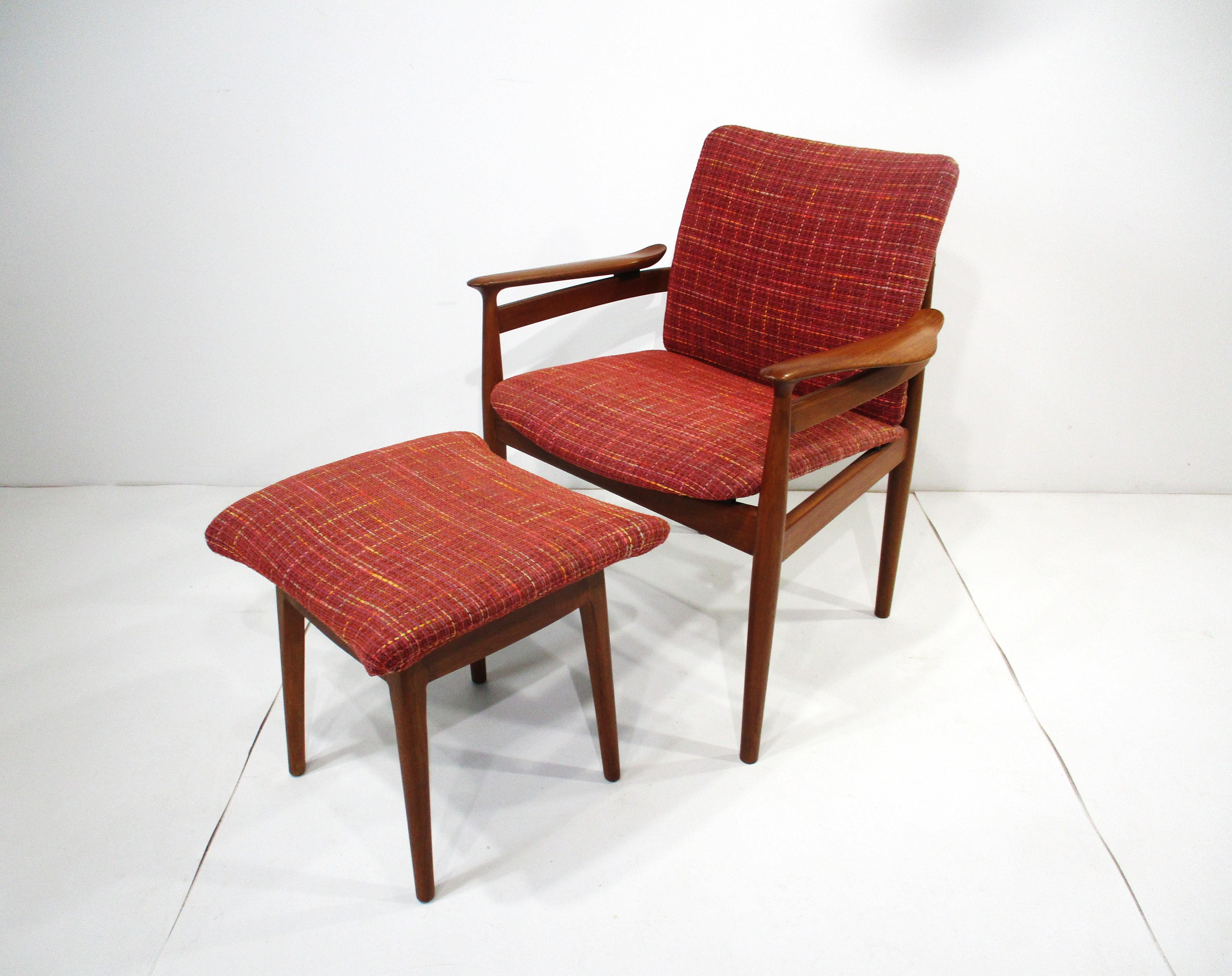 Una poltrona in teak massiccio con seduta imbottita a trama fitta e braccioli scultorei dalle forme meravigliose con il raro pouf. L'iconico designer danese Finn Juhls ha ereditato le sue opere da una lunga serie di abili ebanisti e artisti che