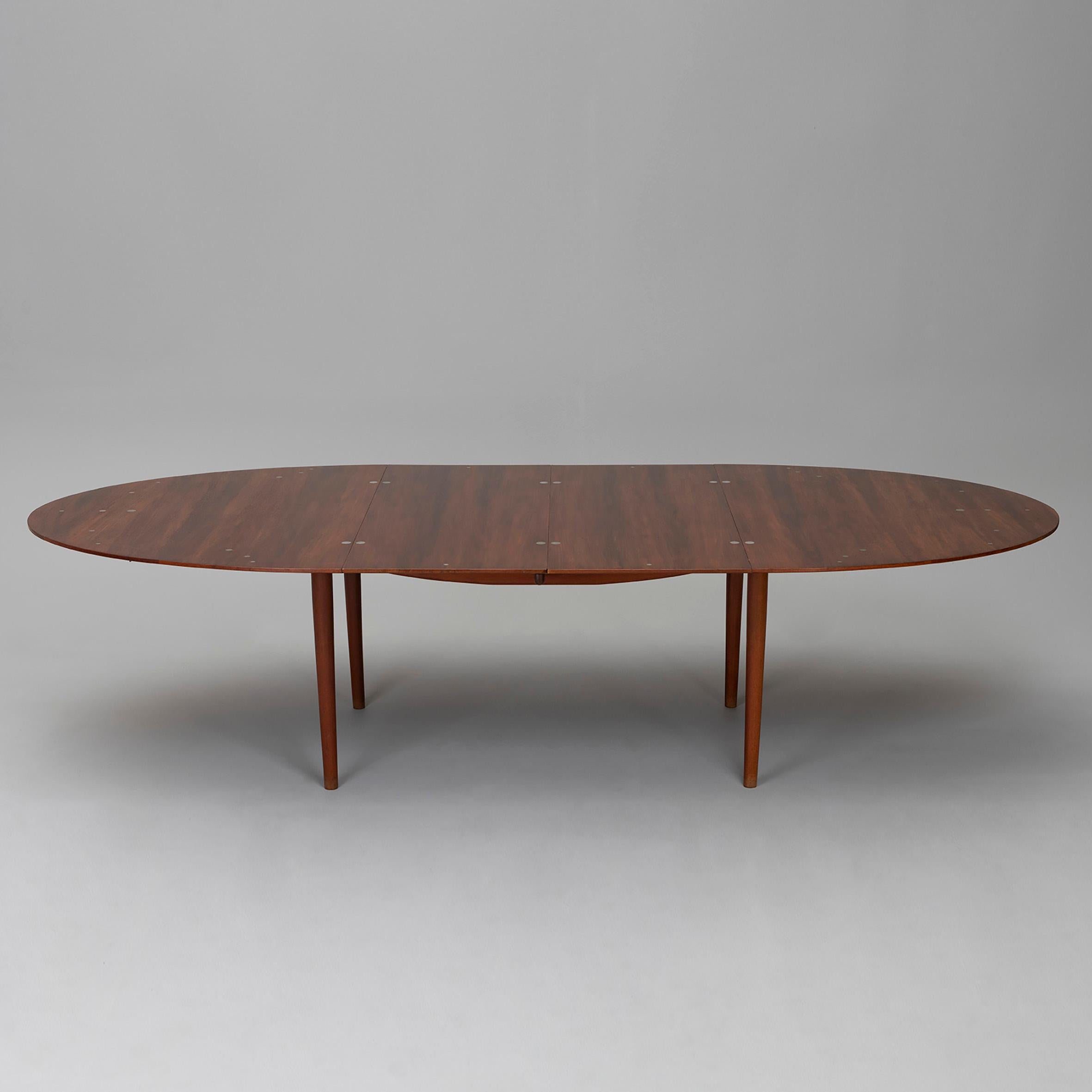 Finn Juhl (1912-1989)
 
“Judas”

An oval teak dining table with silver ‘coins’ inlays and two extension leaves on four feet.
Branded ‘Cabinetmaker Niels Vodder / Copenhagen Denmark / Design: Finn Juhl’.
Produced by Niels Vodder,