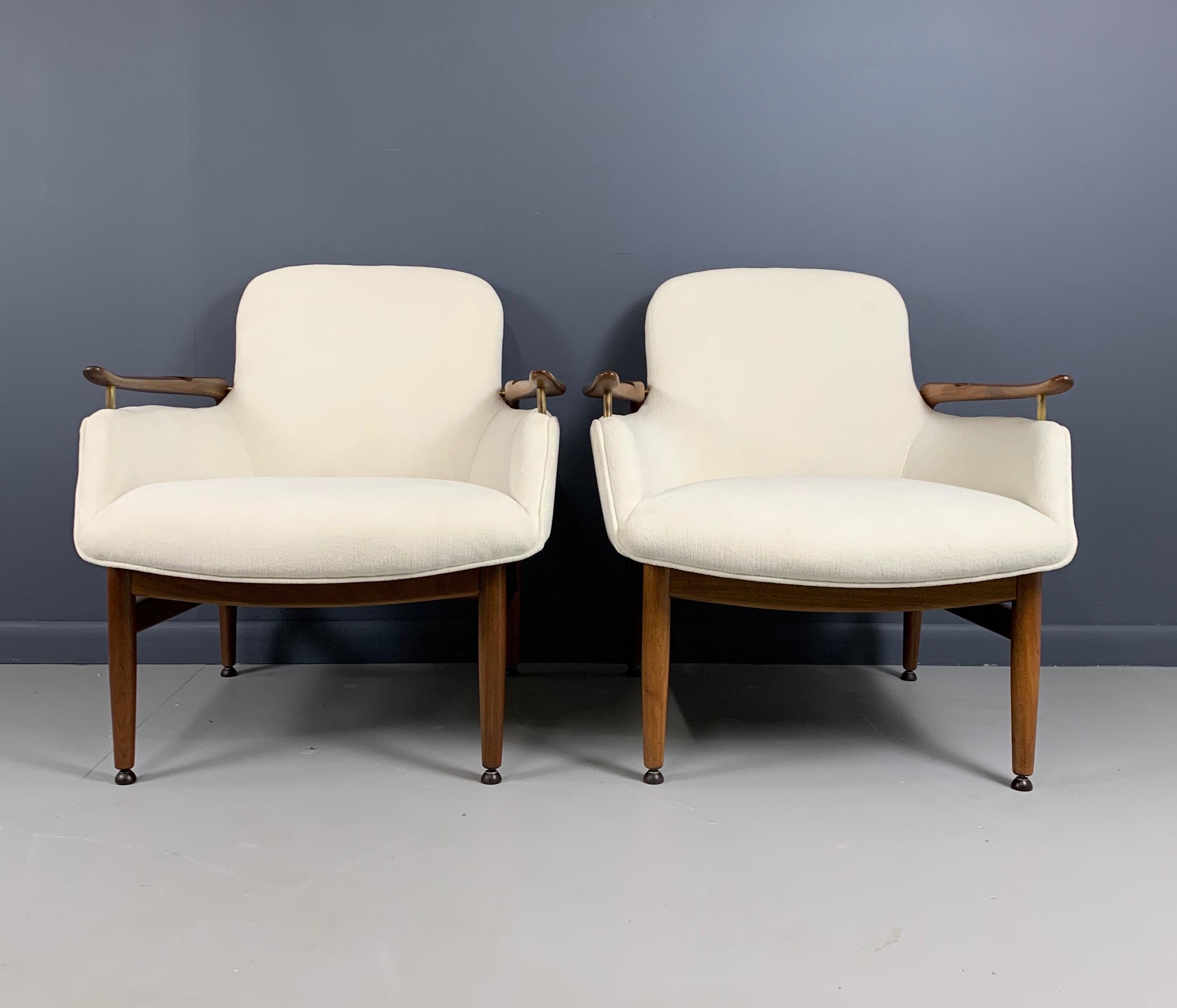 Pair of Finn Juhl NV53 easy chairs with floating armrests, mounted with brass fittings. Re-upholstered with white textured velvet and a complete restoration. Designed, 1953.

Finn Juhl worked in that magical period of mid century masters that