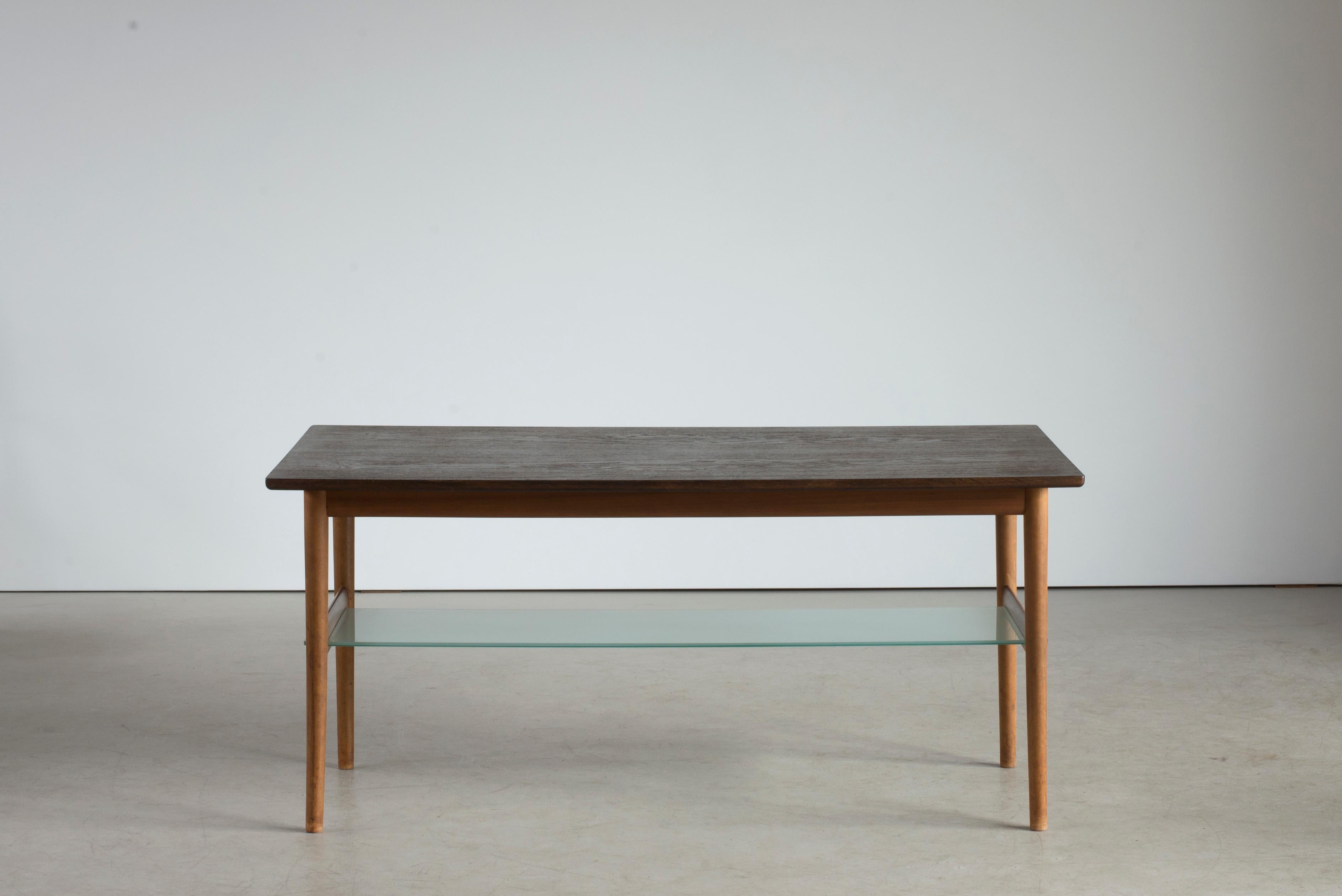Coffee table with walnut frame, rectangular top of marsh oak. Executed by cabinetmaker Niels Vodder, 1955. Stamped by maker. Measures: H. 60 cm., L. 129.5 cm., W. 65 cm.

Acquired at the Copenhagen cabinetmakers' guild exhibition in