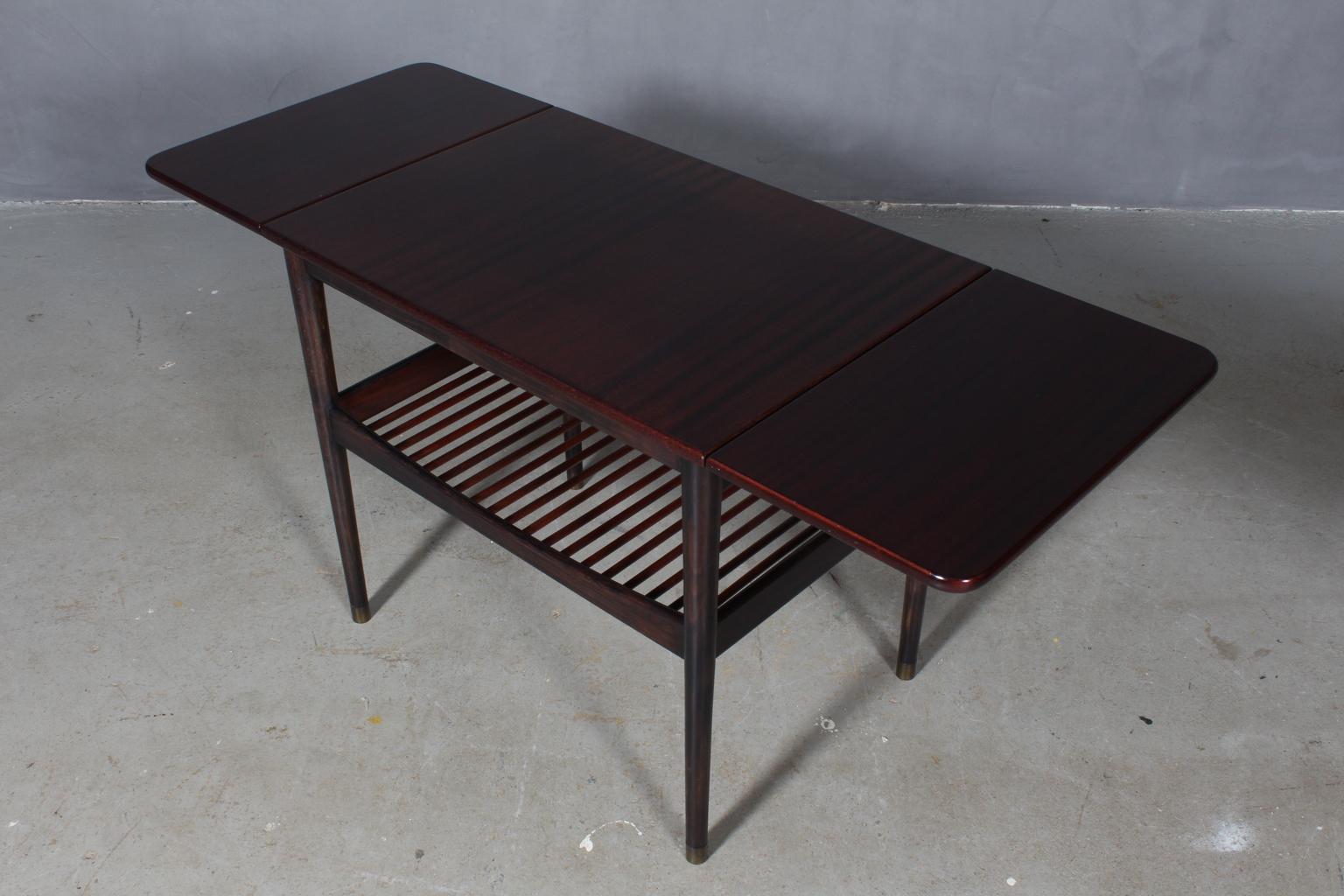 Finn Juhl coffee table with leafes. Made in veneered mahogany and stained beech.

Brass shoes. With newspaper shelf.

Made by Bovirke.