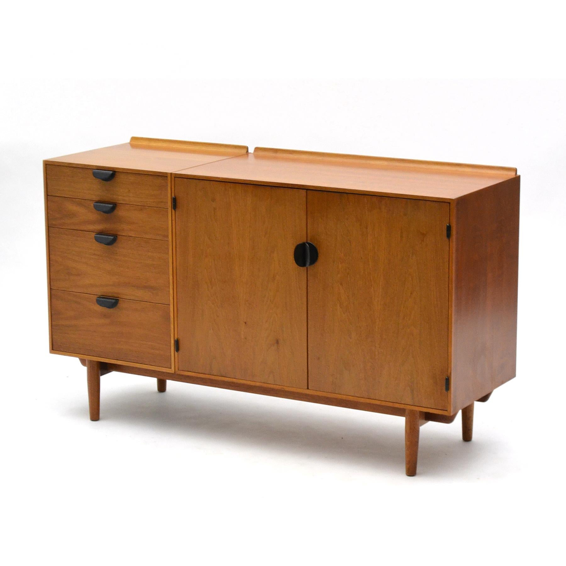A beautiful and highly functional design by Finn Juhl expertly crafted by Baker Furniture in the 1950s, this credenza has two cabinet components supported by an undercarriage base. The left cabinet has four drawers (two shallow, two deep) while the