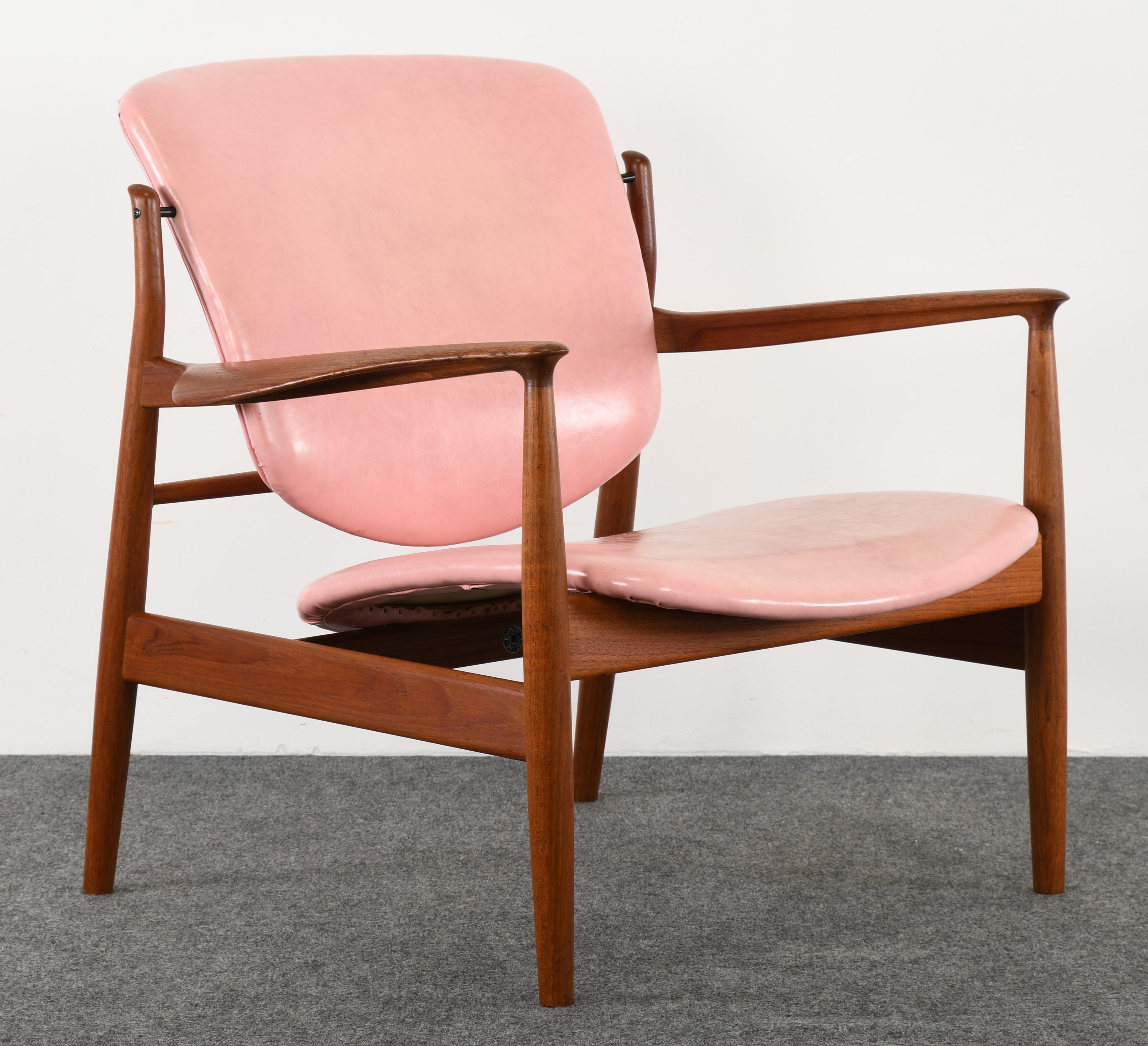 A sculptural early model FD 136 Danish teak chair by Finn Juhl. This beautiful chair has the original pink faux leather upholstery. Inscribed with early mark 