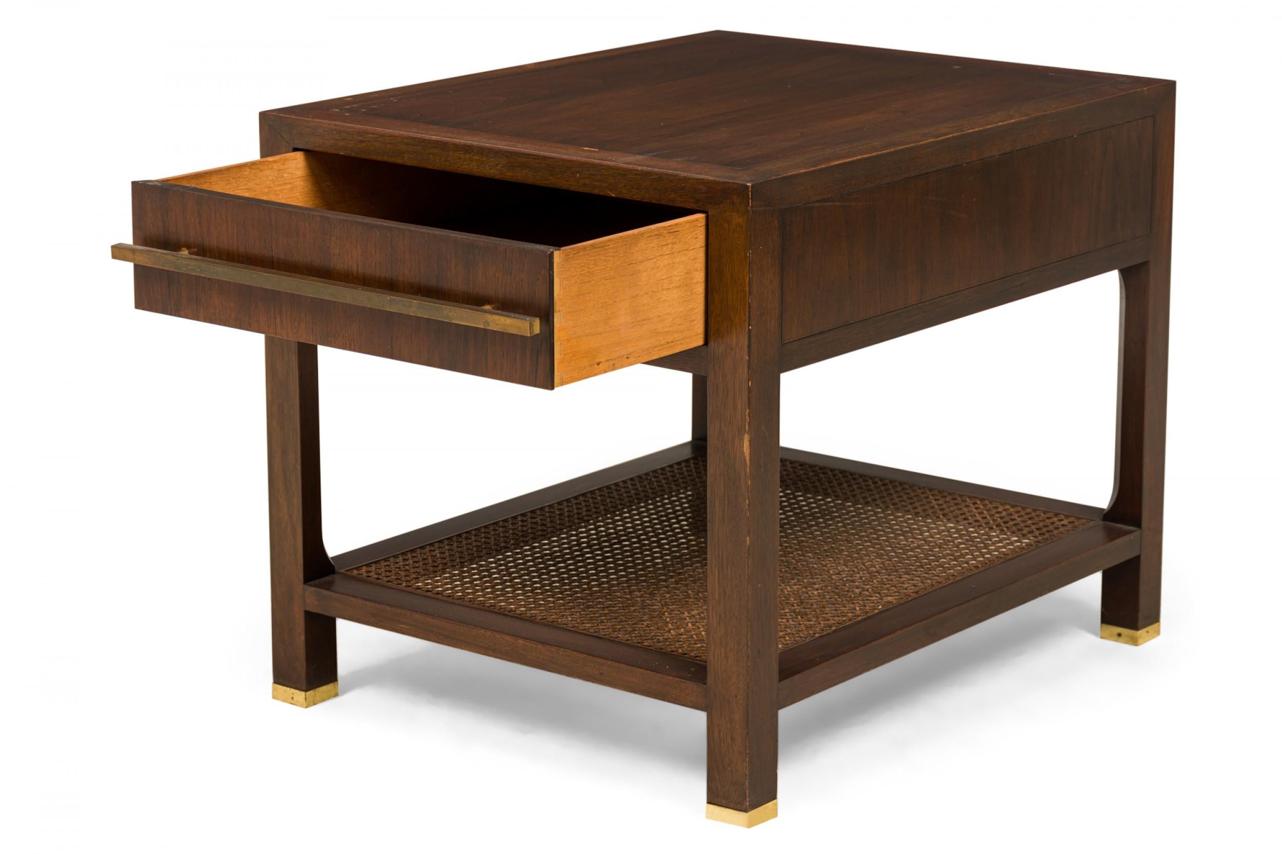 Mesa auxiliar rectangular danesa de mediados de siglo, con armazón de madera teñida y lacada en oscuro, un solo cajón con tirador de barra de latón envejecido y estante inferior de caña, que descansa sobre cuatro patas cuadradas con sabots de latón