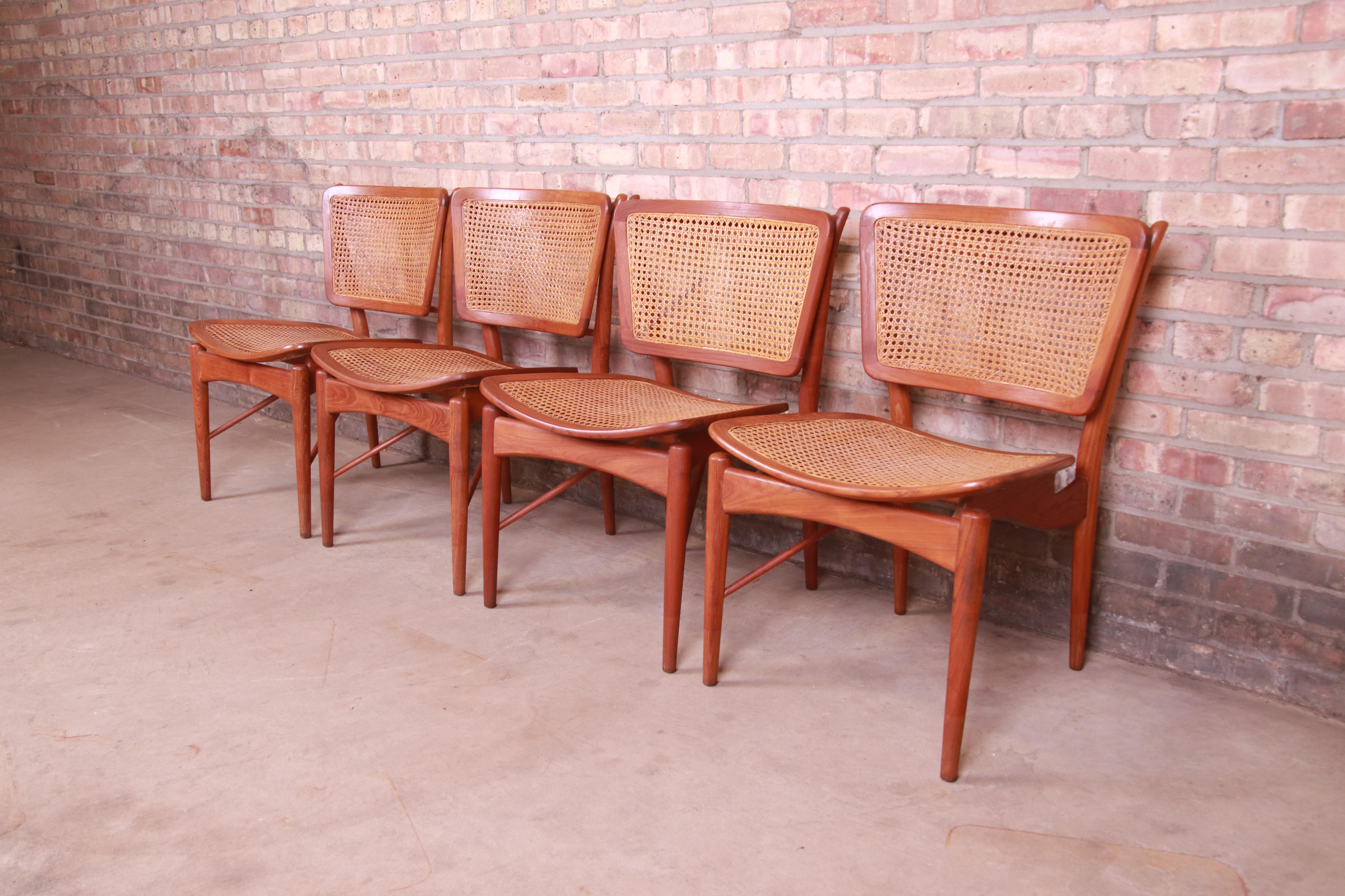 Ein wunderschönes Set aus vier dänischen modernen Esszimmerstühlen aus der Mitte des Jahrhunderts

Von Finn Juhl für Baker Furniture

Indien, 1950er Jahre

Geformte Teakholzrahmen, Sitz und Rückenlehne mit Rohrgeflecht.

Maße: 21