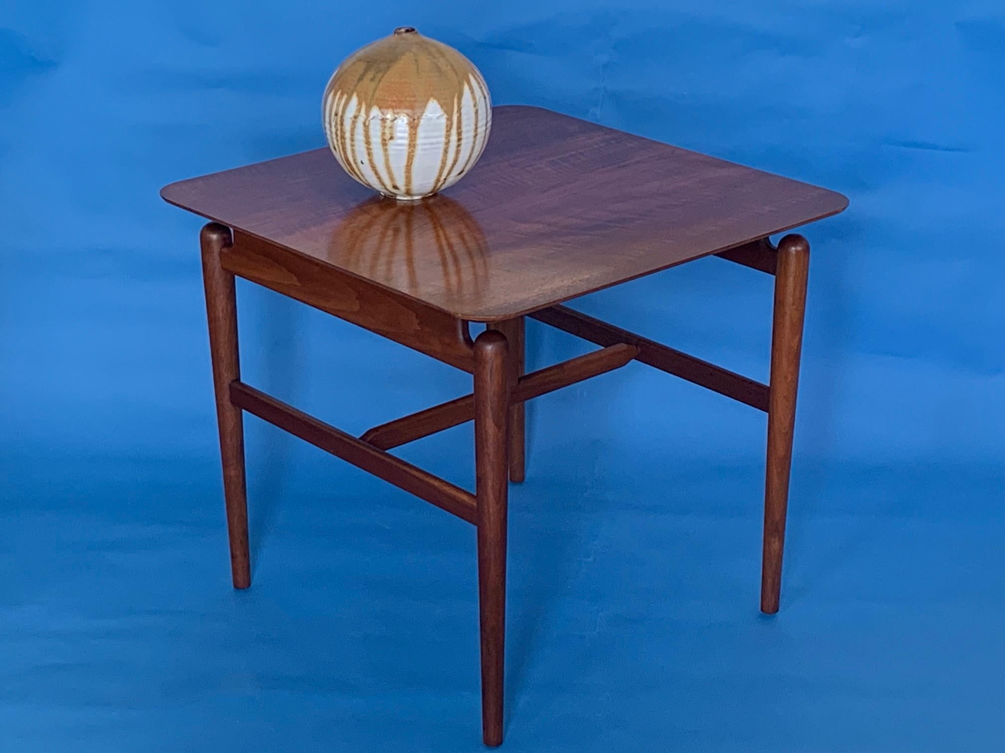 A classic occasional or lamp table designed by Finn Juhl and produced by Baker, circa 1950s. Beautiful American walnut with hand polished, floating top. Finely crafted in the great Baker Furniture tradition.