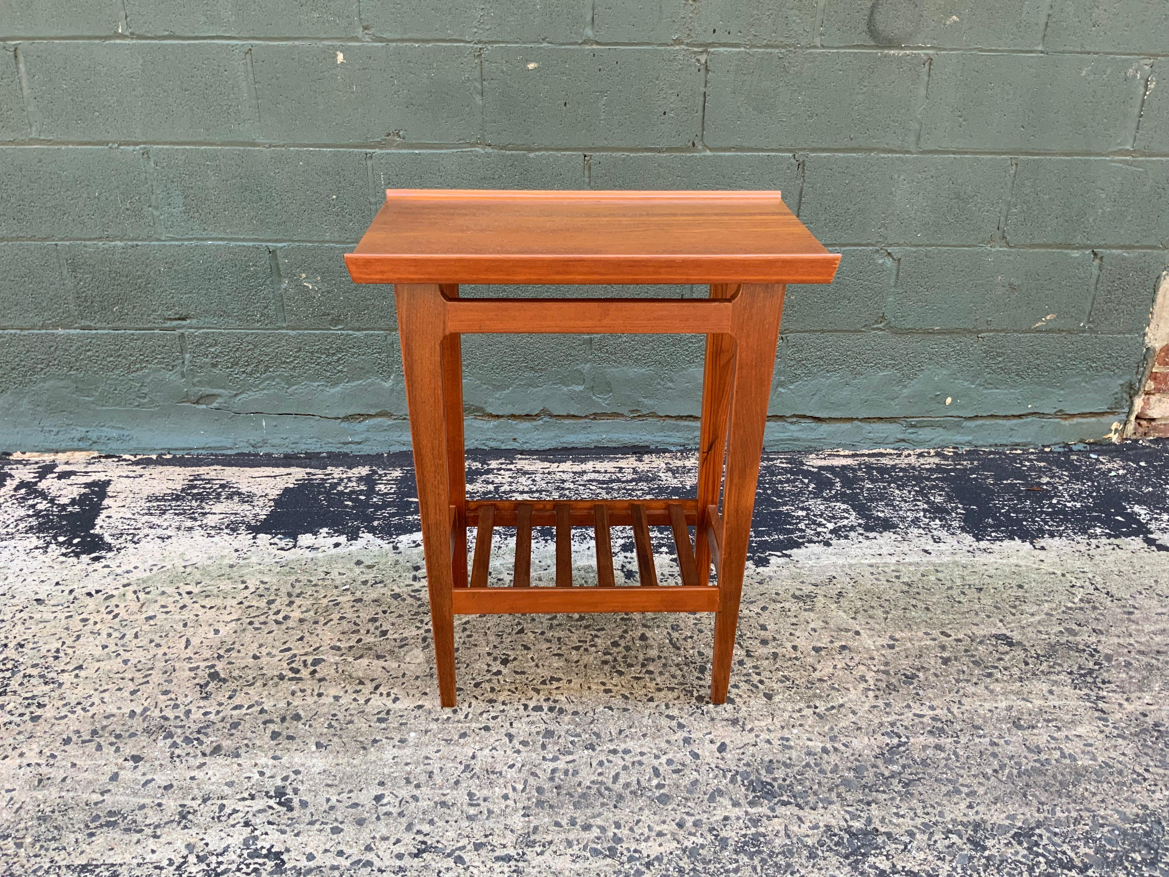 Finn Juhl design for France and Daverkosen solid teak end table. Austere and refined Danish modern Design. The table features solid teak construction, tapered legs, open slat lower shelf and beveled top edge, circa 1955. Unsigned.

Measures: 14