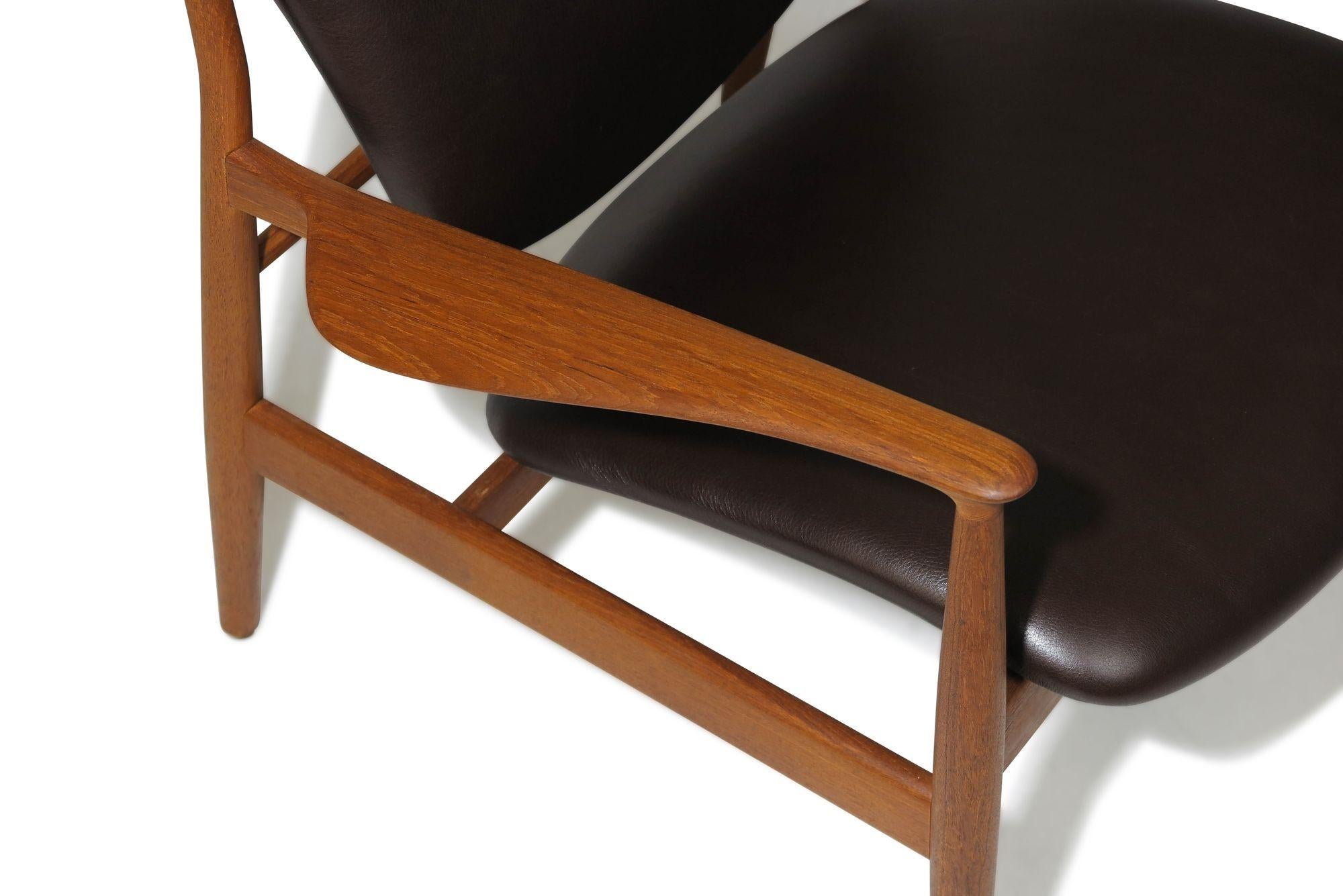 Scandinavian lounge chair designed by Finn Juhl for France & Daverkosen, Denmark. Model FD 136 is skillfully handcrafted from beautiful old-growth teak wood. The chair boasts elegantly carved armrests and a gracefully curved seat and backrest.