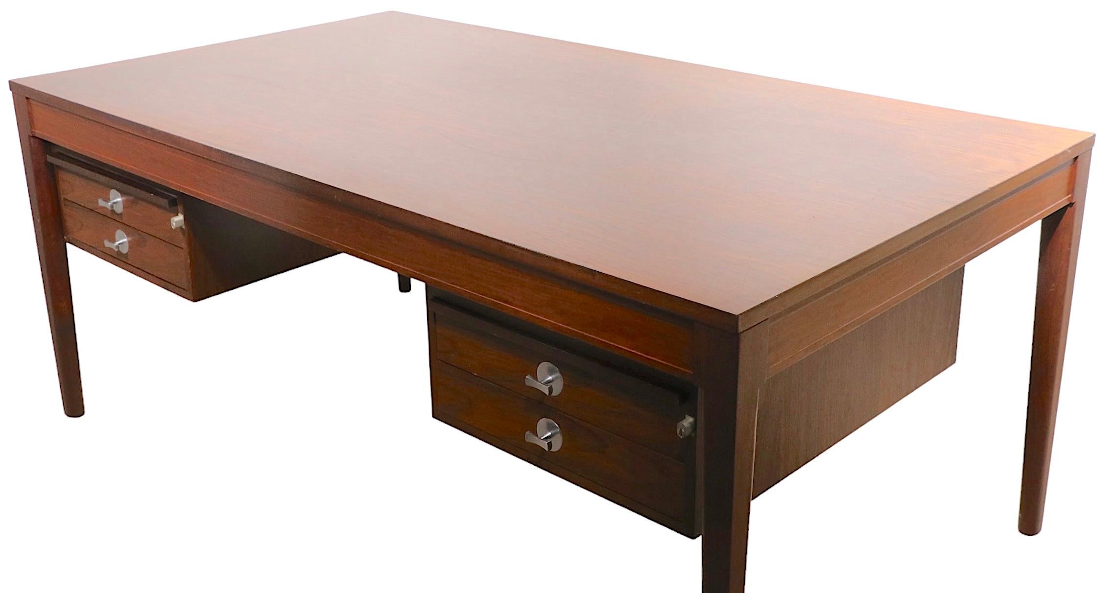 Large rosewood executive Diplomat model desk, model FD-951, designed by Finn Juhl, made by France & Son circa 1960. This classic desk features two banks of locking drawers, each with two drawers, and pull out glass top writing surfaces. This example