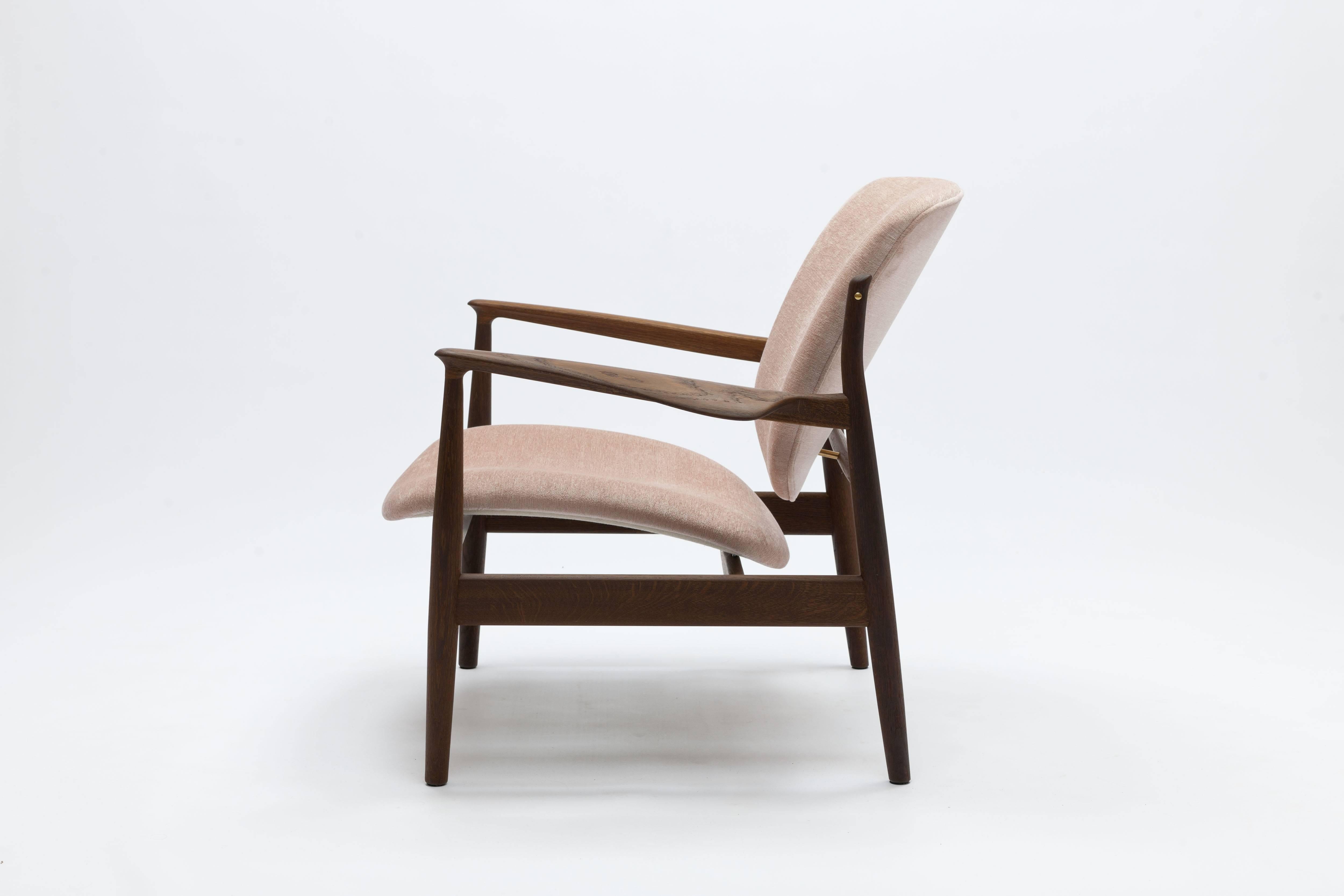 France chair by Finn Juhl, made by House of Finn Juhl Denmark. Frame of solid smoked oak with brass hardware beautifully upholstered in a pale pink bespoke fabric by Sahco Hesslein. 
For color and quality reference we can always send you a fabric