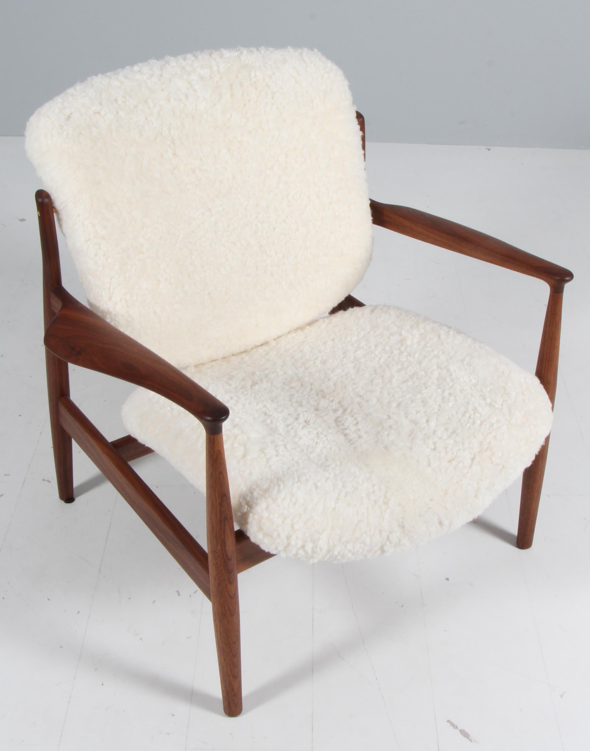 Finn Juhl lounge chair in solid walnut. 

Upholstered with white shearling.

Model France, made by Onecollection.