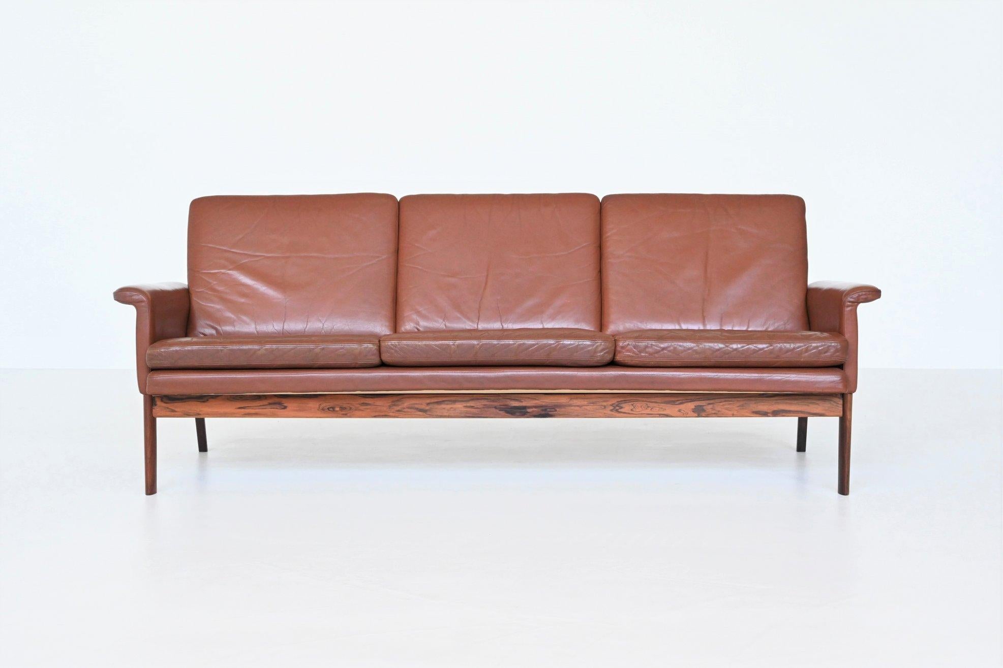 Magnifique canapé 3 places Jupiter modèle 218 conçu par Finn Juhl pour France & Son, Danemark 1965. Le canapé est exécuté en cuir brun chocolat soutenu par un cadre en bois de rose massif. Il présente des lignes épurées et des détails subtils tels