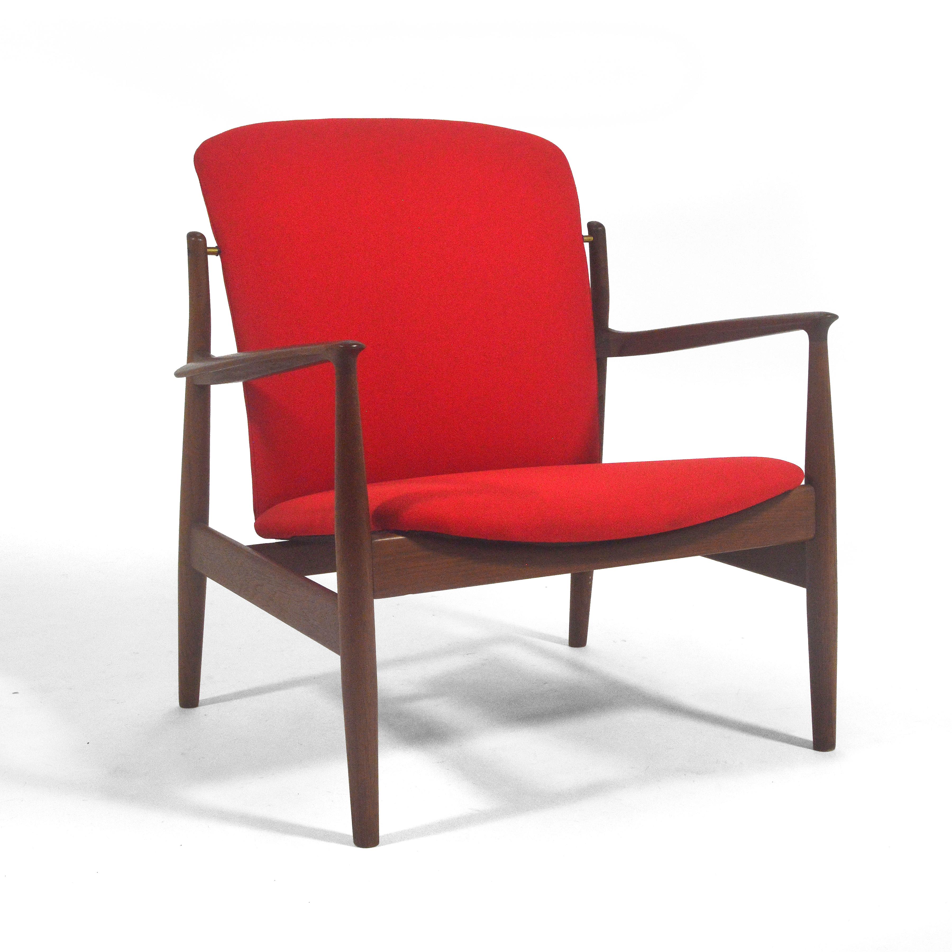 This handsome easy chair by Finn Juhl for France & Sons is a rare model fd141. It shares qualities with many of his famous chairs including the Chieftain, the #45 chair, and the Delegate's chair. The dark, rich teak frame supports a set upholstered