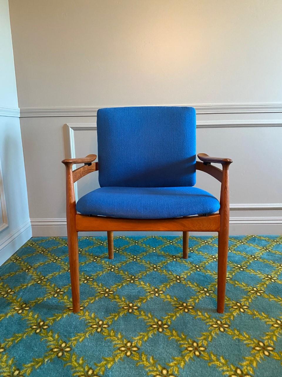 Designed by Finn Juhl for France & Son and imported by John Stuart, this handsome set of chairs features generous and comfortable seats that float within teak frames. They are upholstered in an original beautiful blue boucle fabric. In great
