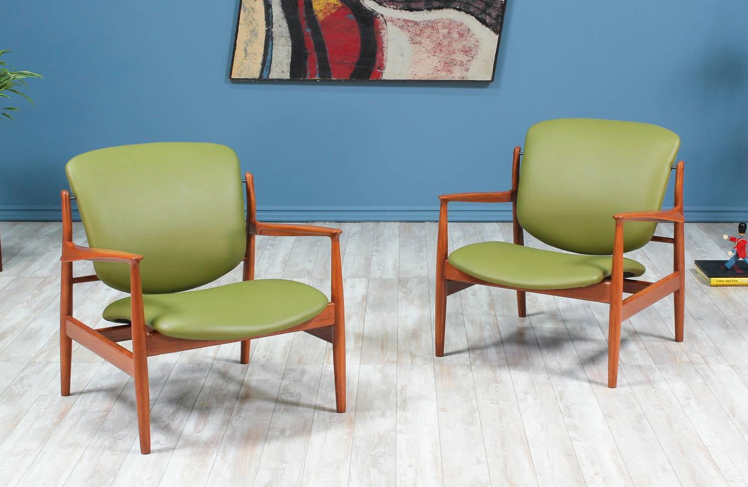 Model FD-136 chairs designed by Finn Juhl for France & Daverkosen in Denmark circa 1950’s. This pair of open wood frame lounge chairs feature a teak structure with sculpted armrests and have been reupholstered with the highest quality grain leather