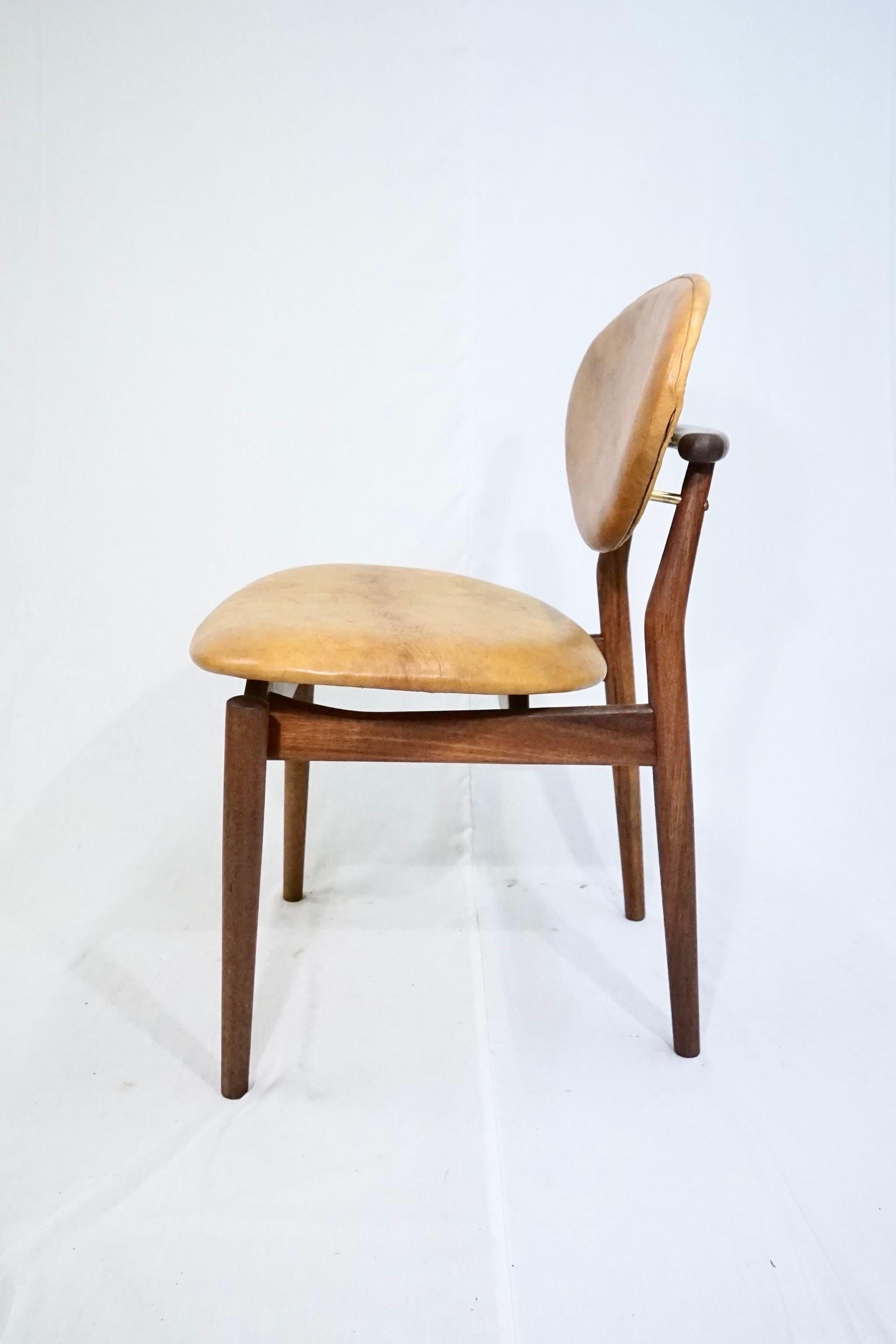 Rare Finn Juhl model FJ55 in solid teak upholstered in patinaed Niger leather manufactured by Niels Vodder.

This chair is made in two models one with two stretchers underneath the seat and this version which is without the stretchers.