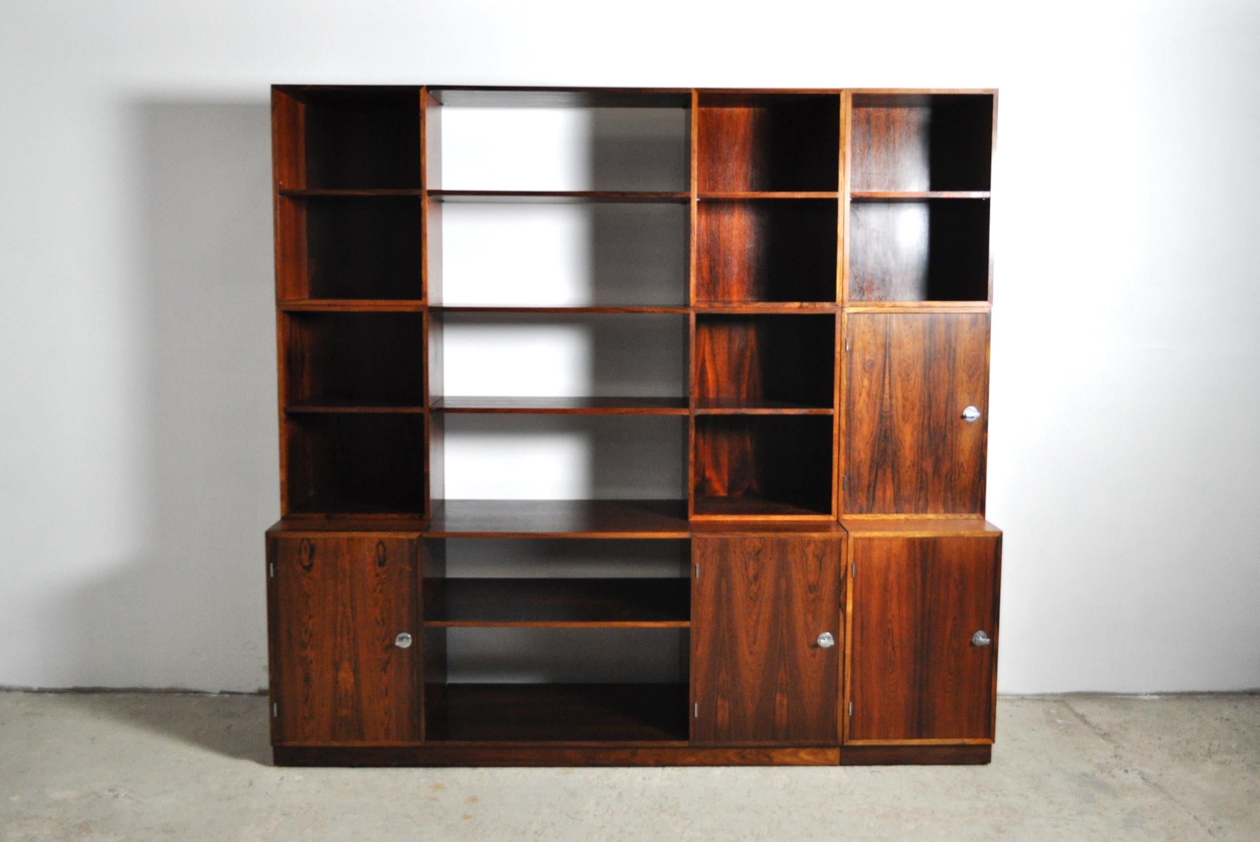 Finn Juhl Modular rosewood storage system model Cresco designed 1966 for France & Søn. The wall unit comprises four cabinets, five bookcases, multiple shelves, a triple and a single plinth. The cabinets feature signature aluminum bowtie pulls. 
It