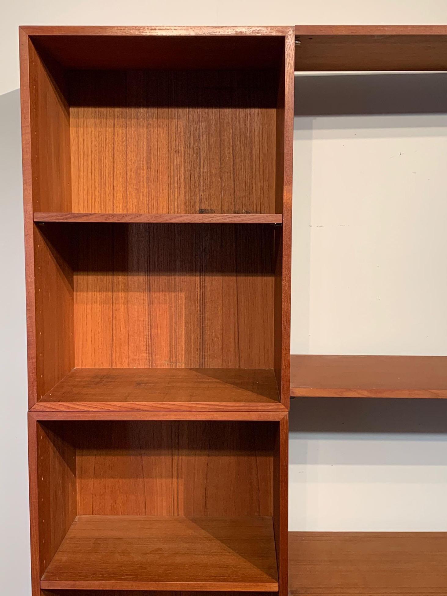 A Finn Juhl Cresco teak wall unit/room divider of two cabinets with doors, four open cabinets with adjustable shelves, and various other shelves. Denmark, France & Sons, with John Stuart medallion and France & Sons mark. Signature Iconic Finn Juhl