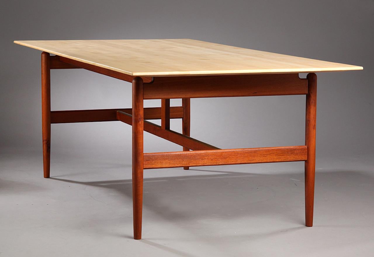 Finn Juhl 1912-1989. Dining table / work table with solid teak wood frame, with recessed brass strips in cross-section. Newer floating plate of solid marble with profiling along the underside of the plate. Manufactured by cabinetmaker Niels Vodder,